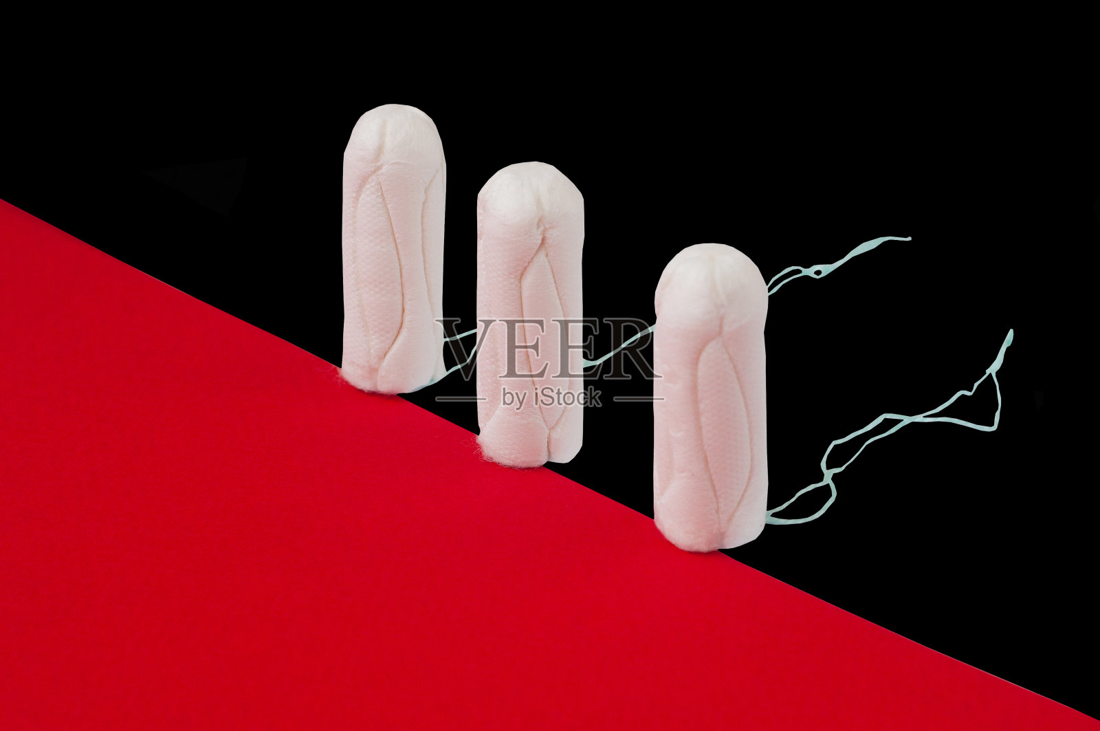 女性卫生的白色卫生棉条。棉拭子。月经,防护设备。黑色和红色背景的卫生棉条。广告的概念照片摄影图片