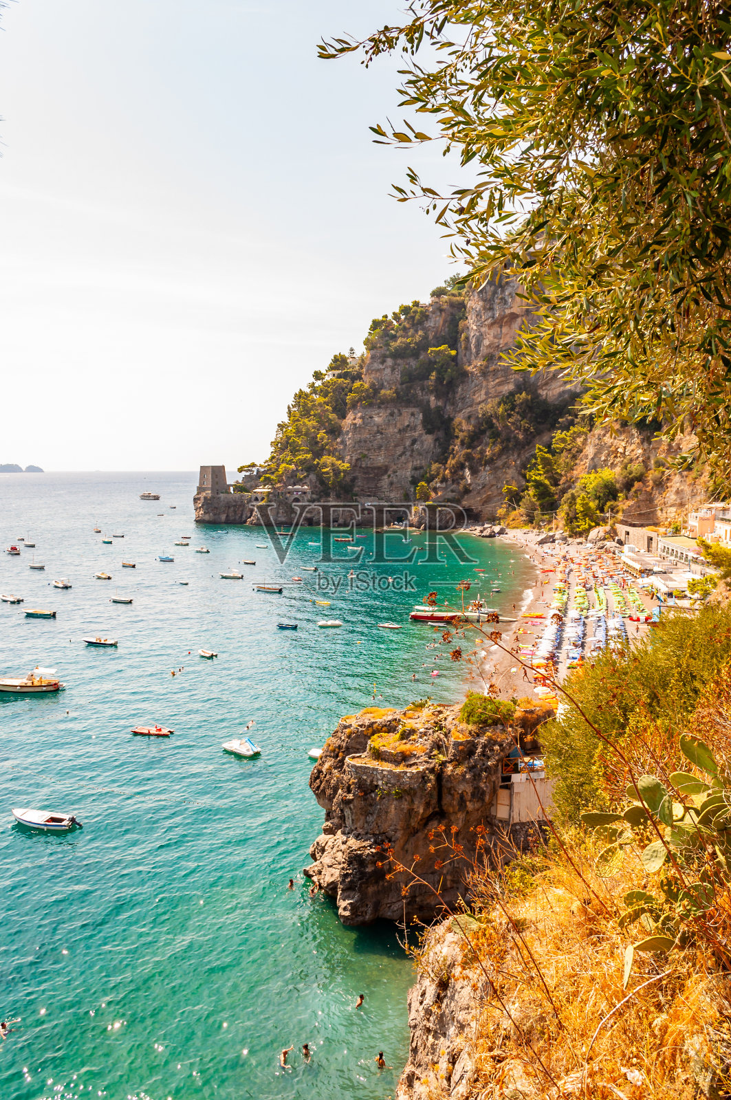 波西塔诺市景观上的岩石景观，人们在海滩上，船来了又去的海上旅游，风景长廊上的岩石山边缘被常绿的树木和植物包围照片摄影图片