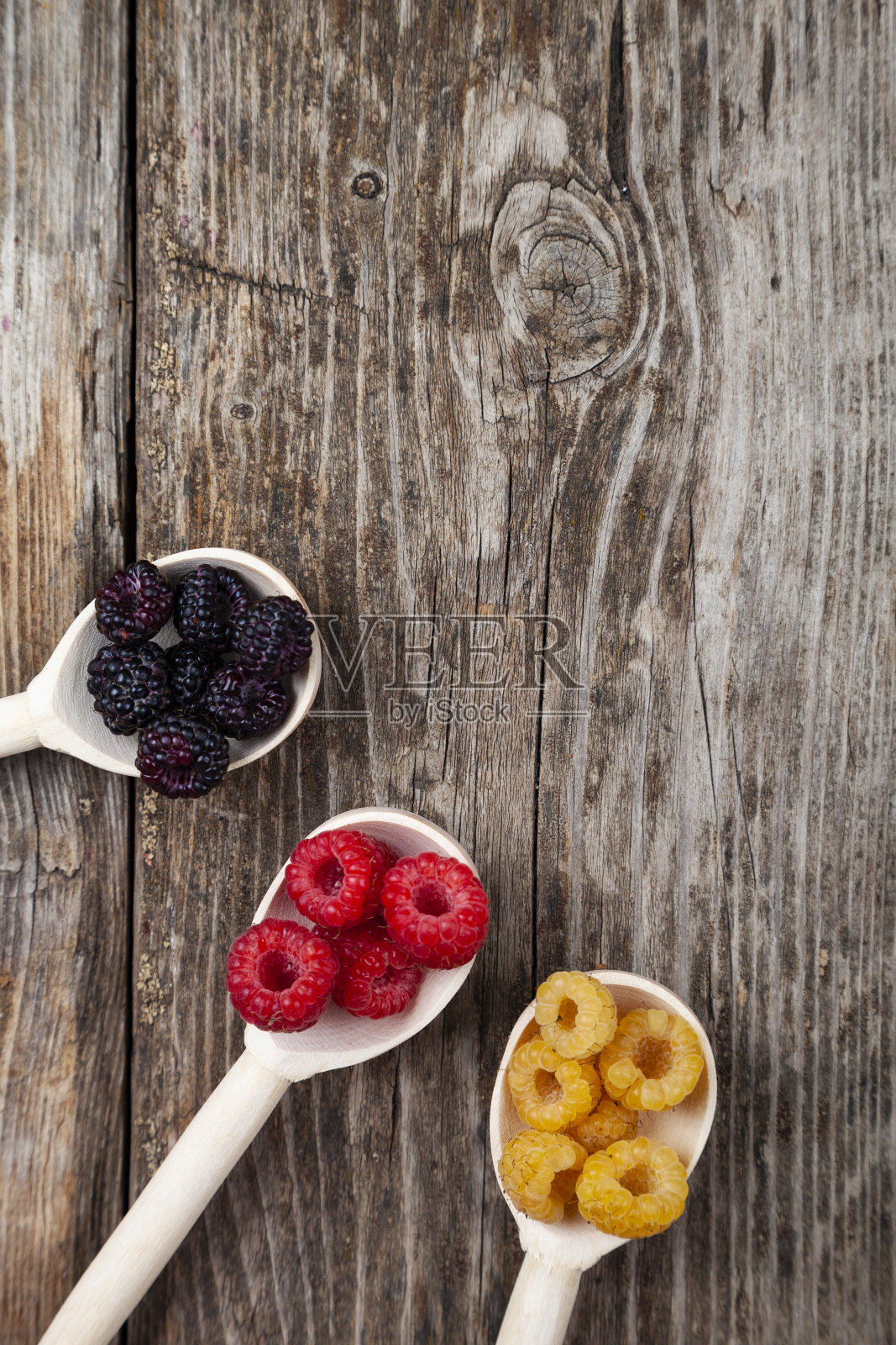 成熟的红色和黄色的覆盆子和黑莓勺照片摄影图片