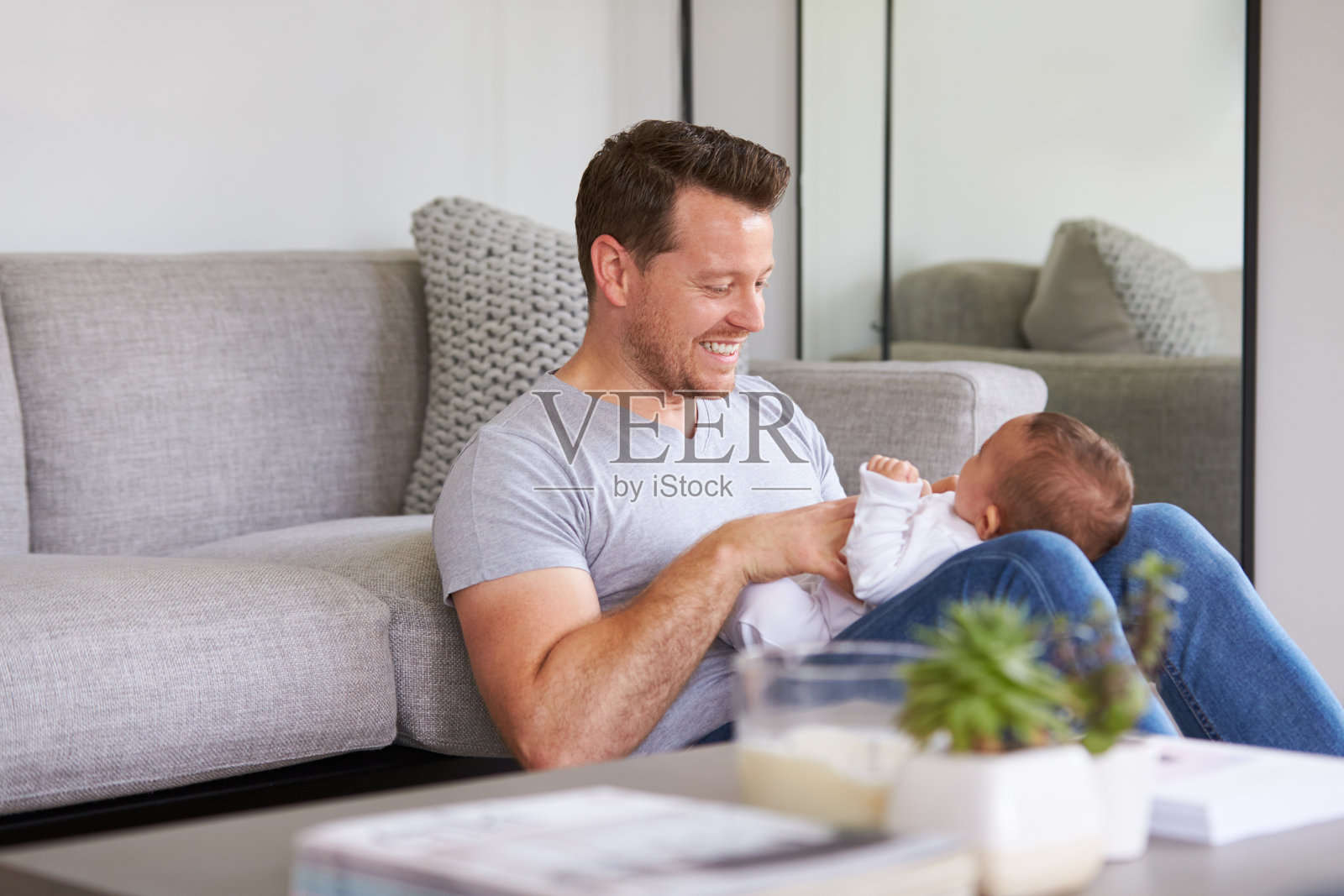 爸爸在家和女儿玩游戏时，女儿躺在爸爸的腿上照片摄影图片