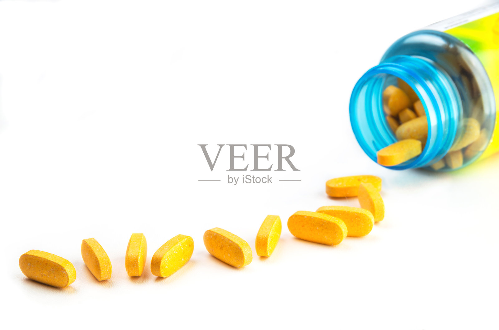 橙色的维生素片和白色背景的塑料瓶照片摄影图片