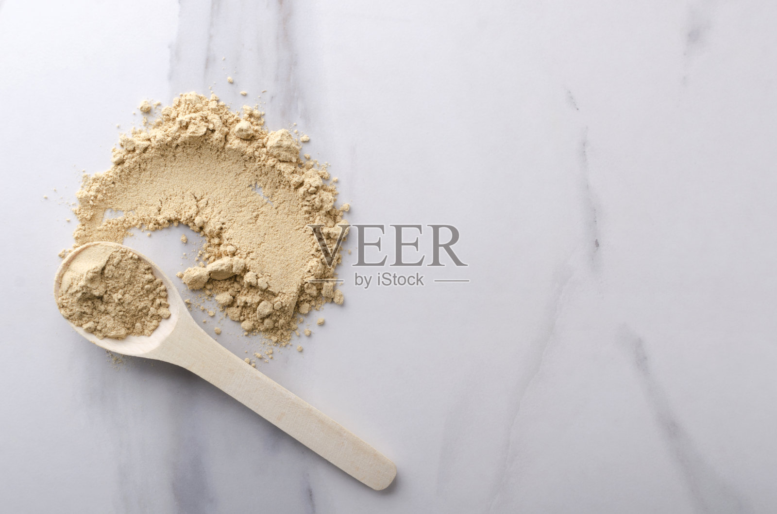 俯视图木勺和涂抹在厨房桌上的干姜粉。文本空白照片摄影图片