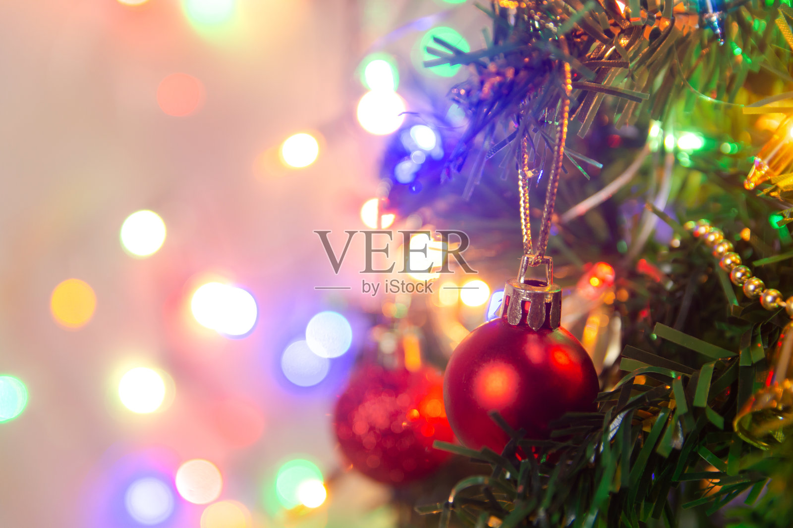 圣诞装饰。在松树树枝上挂红球、圣诞树、花环和装饰物，在抽象的散景背景上复制空间照片摄影图片