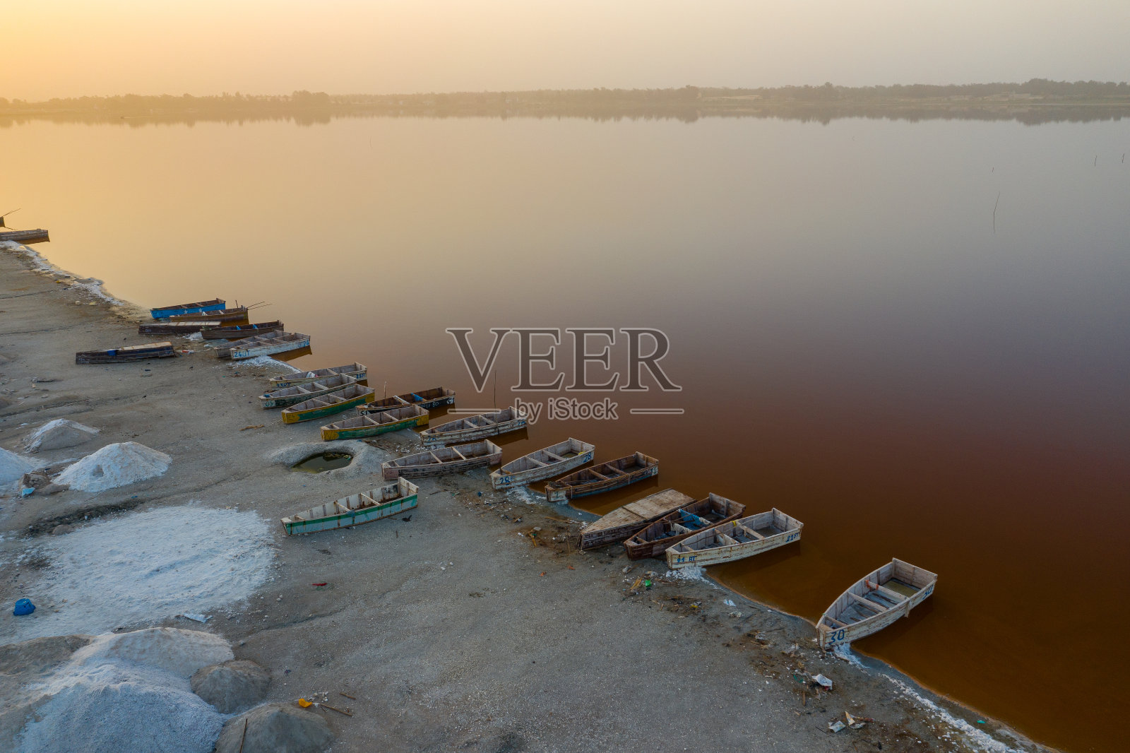 鸟瞰图在粉红色的雷特巴湖或拉克玫瑰在塞内加尔收集盐的小船。无人机从上面拍摄的照片。非洲的自然景观。照片摄影图片