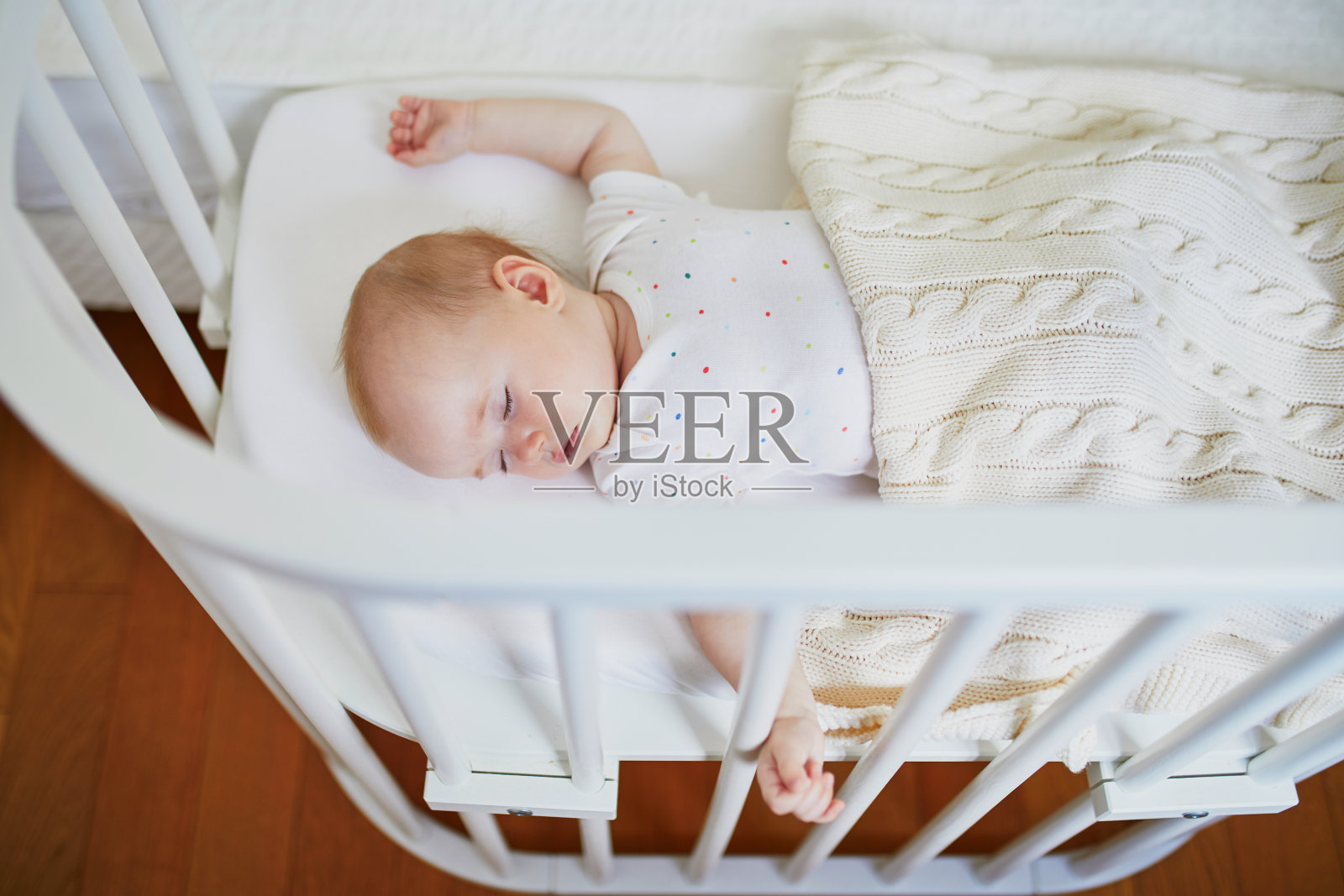 婴儿睡在附在父母床上的同床共枕床上照片摄影图片