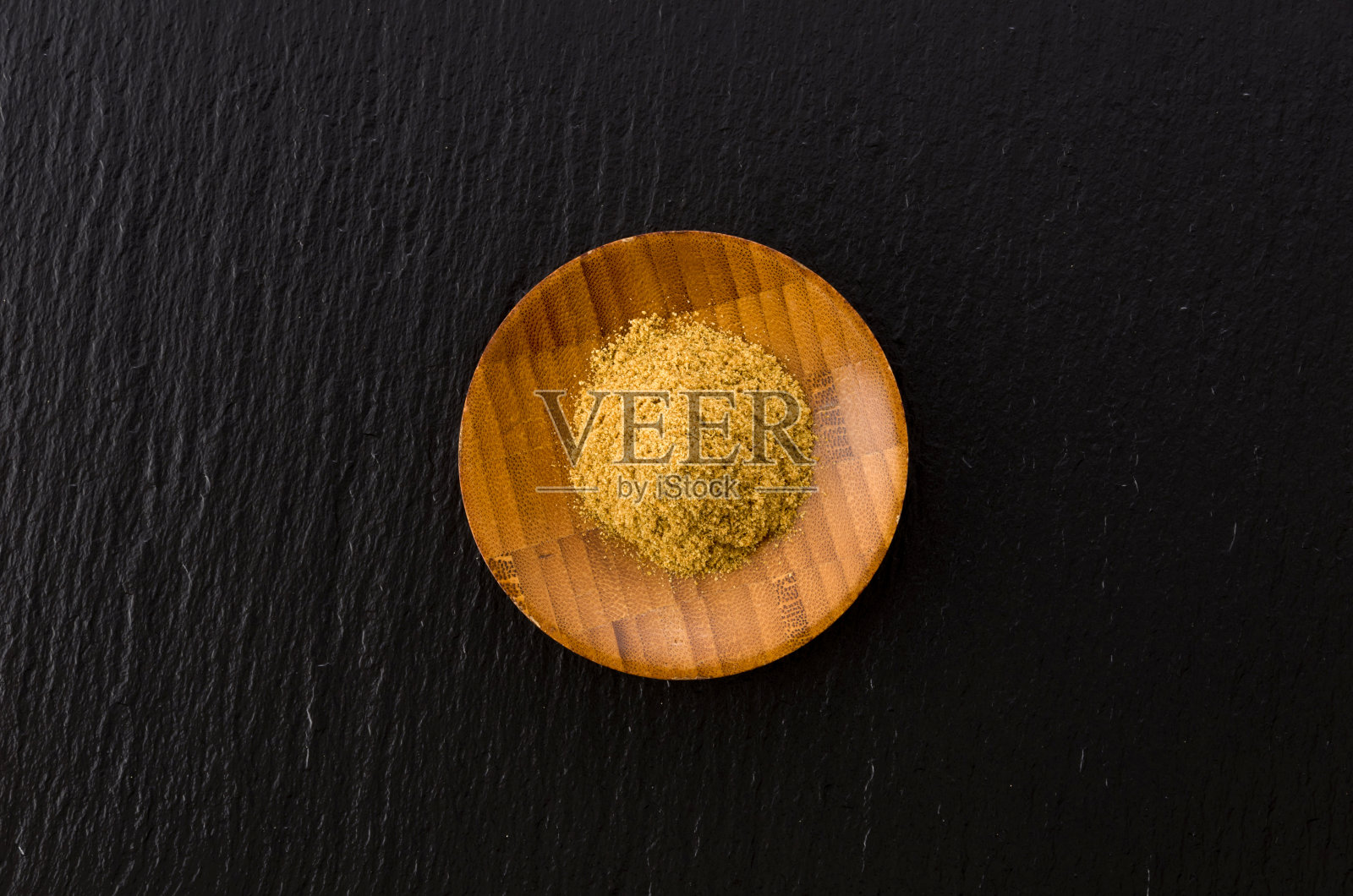 小茴香粉在木盘上黑色的石板背景照片摄影图片