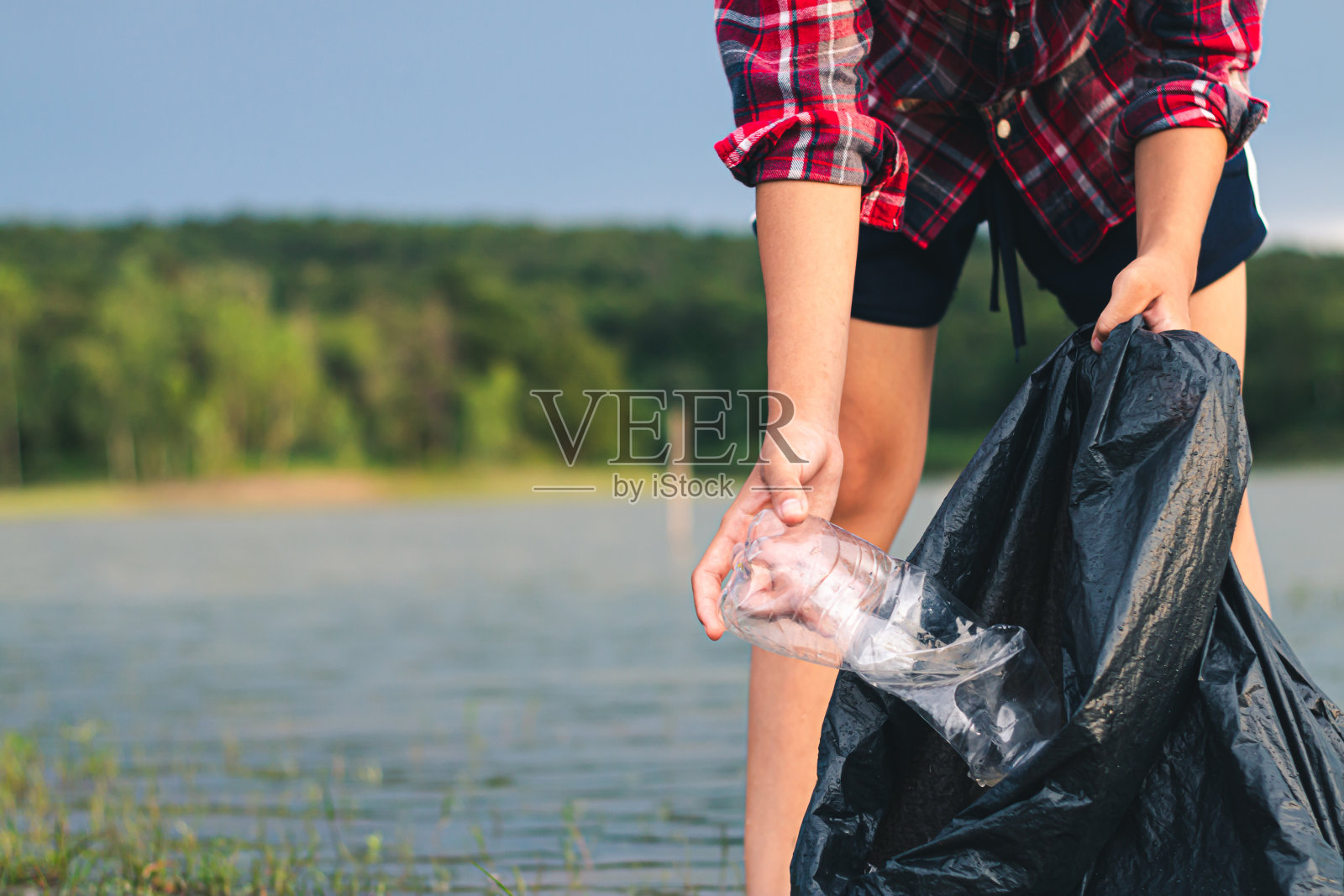 女性志愿者帮助垃圾回收和停止使用塑料来减少全球变暖。照片摄影图片