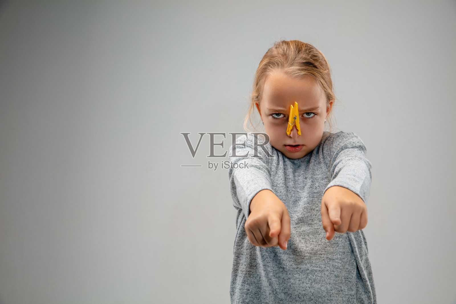 白人女孩戴着呼吸保护别针扣，以防止空气污染和黄昏在灰色的工作室背景照片摄影图片