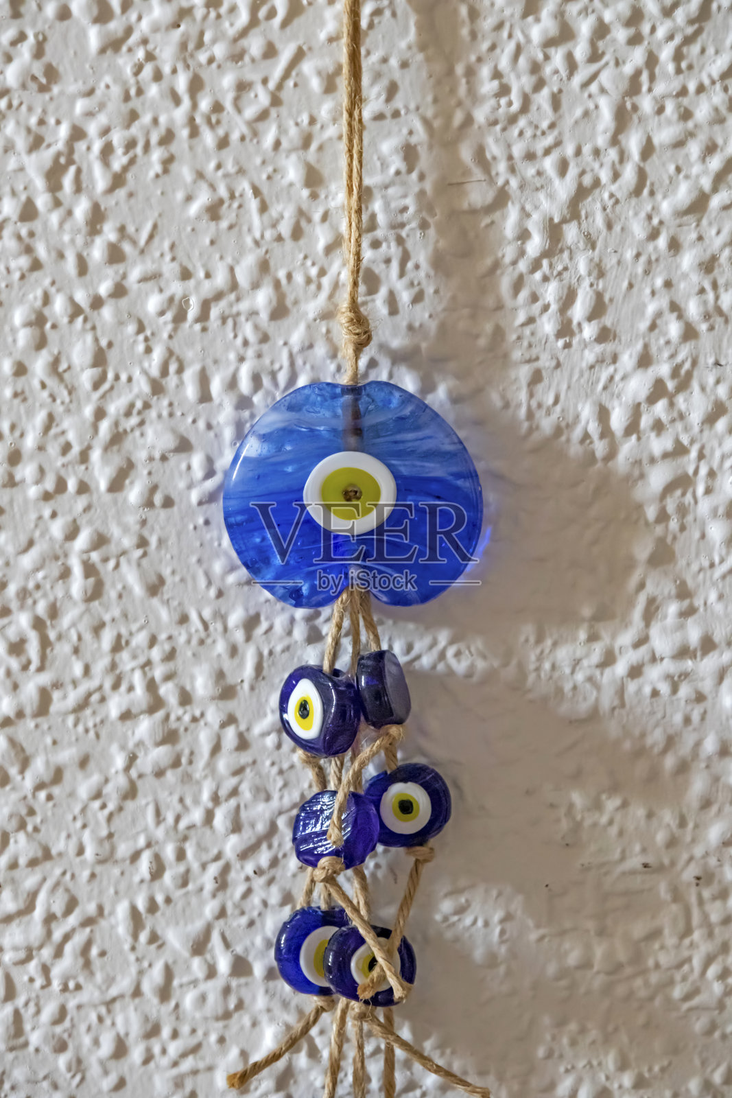 靠近墙上的蓝色魔眼珠照片摄影图片