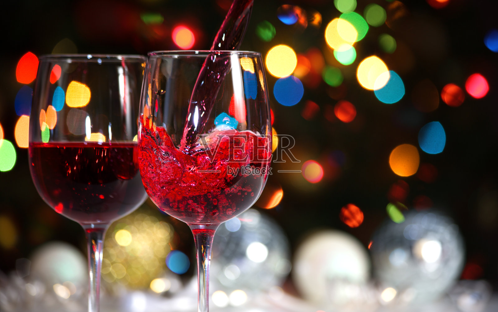 圣诞彩灯背景下的酒杯和圣诞舞会照片摄影图片