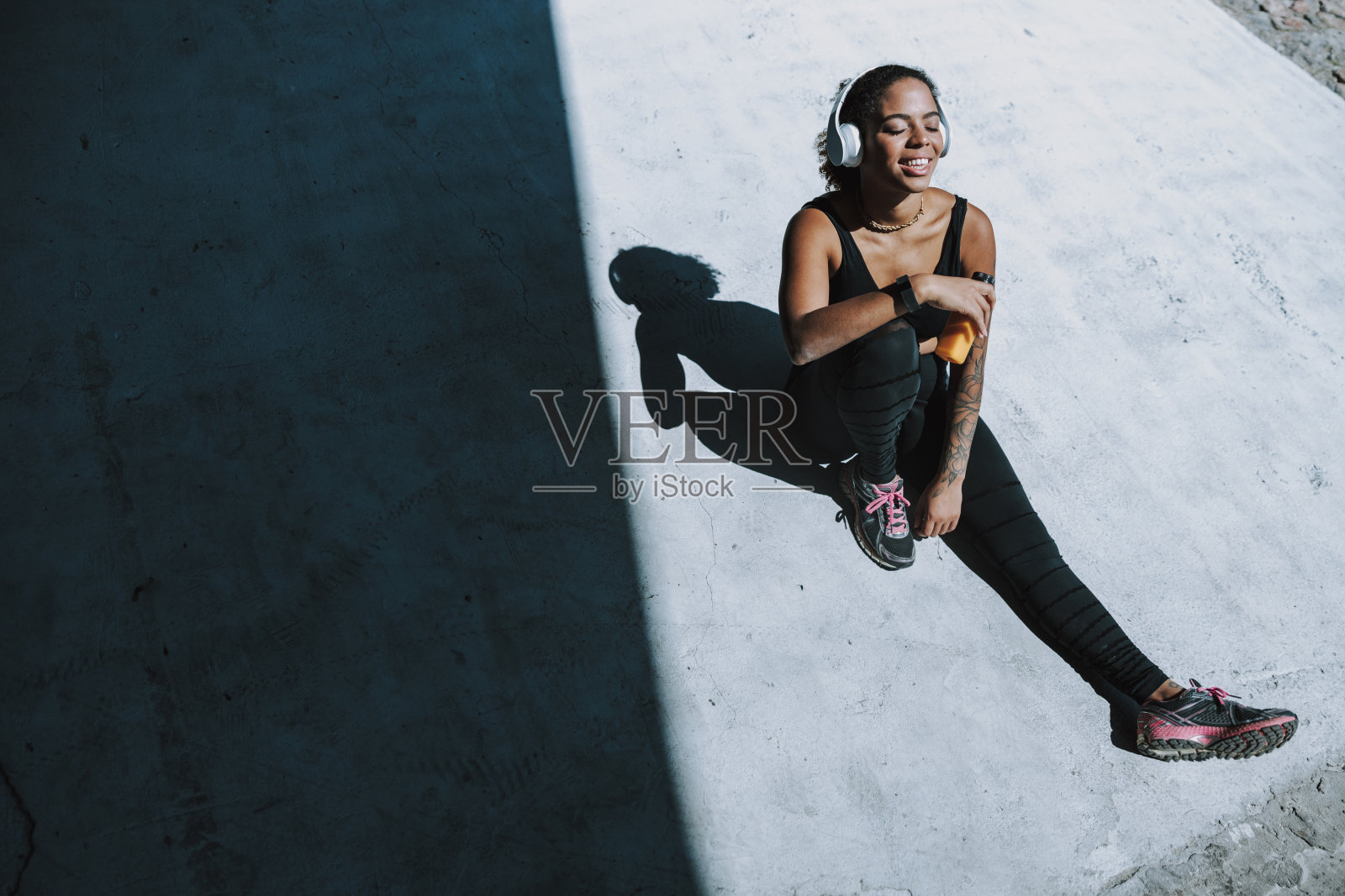 美丽的美国黑人女士戴着耳机在户外休息照片摄影图片