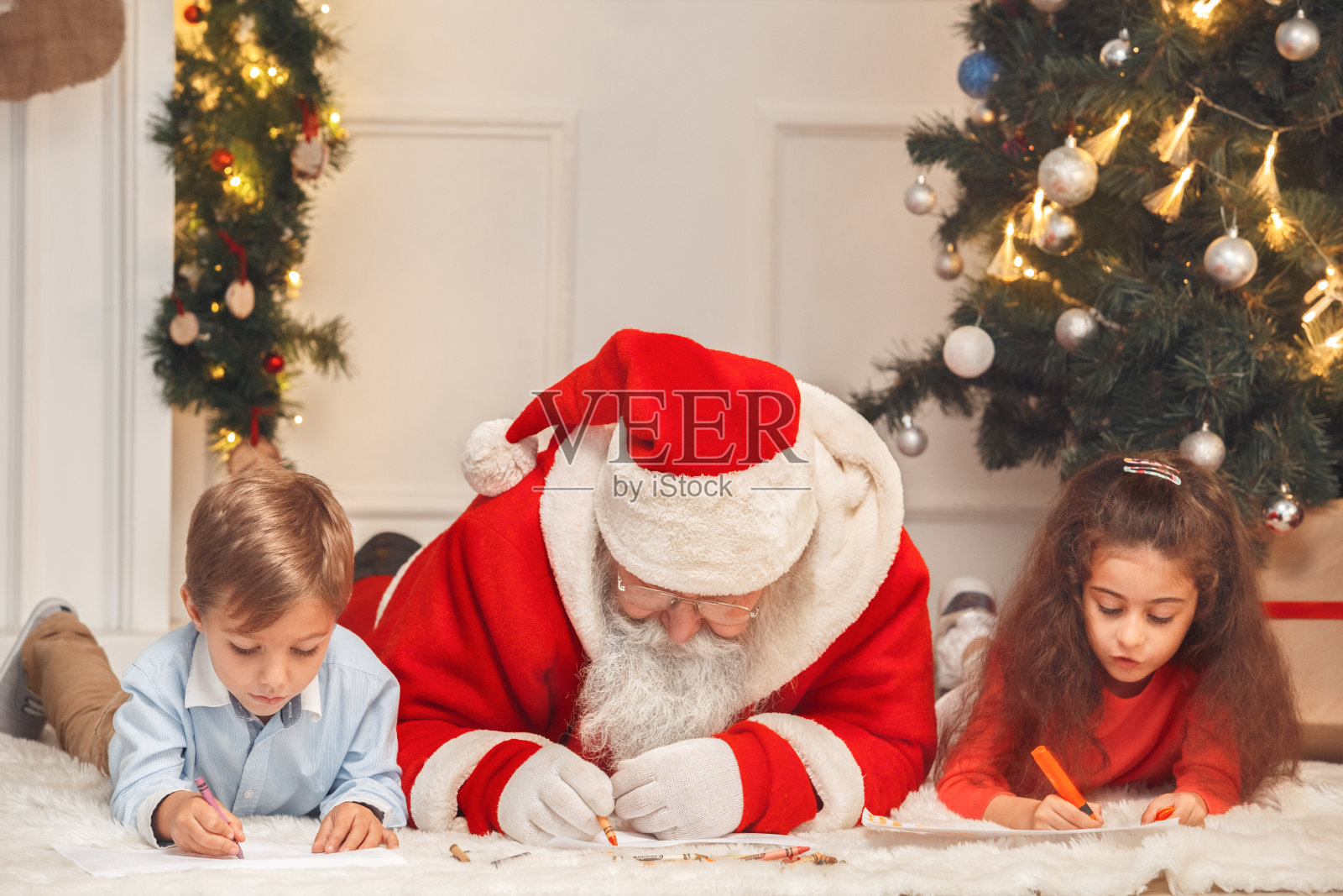 圣诞老人和孩子在室内庆祝圣诞节的概念照片摄影图片