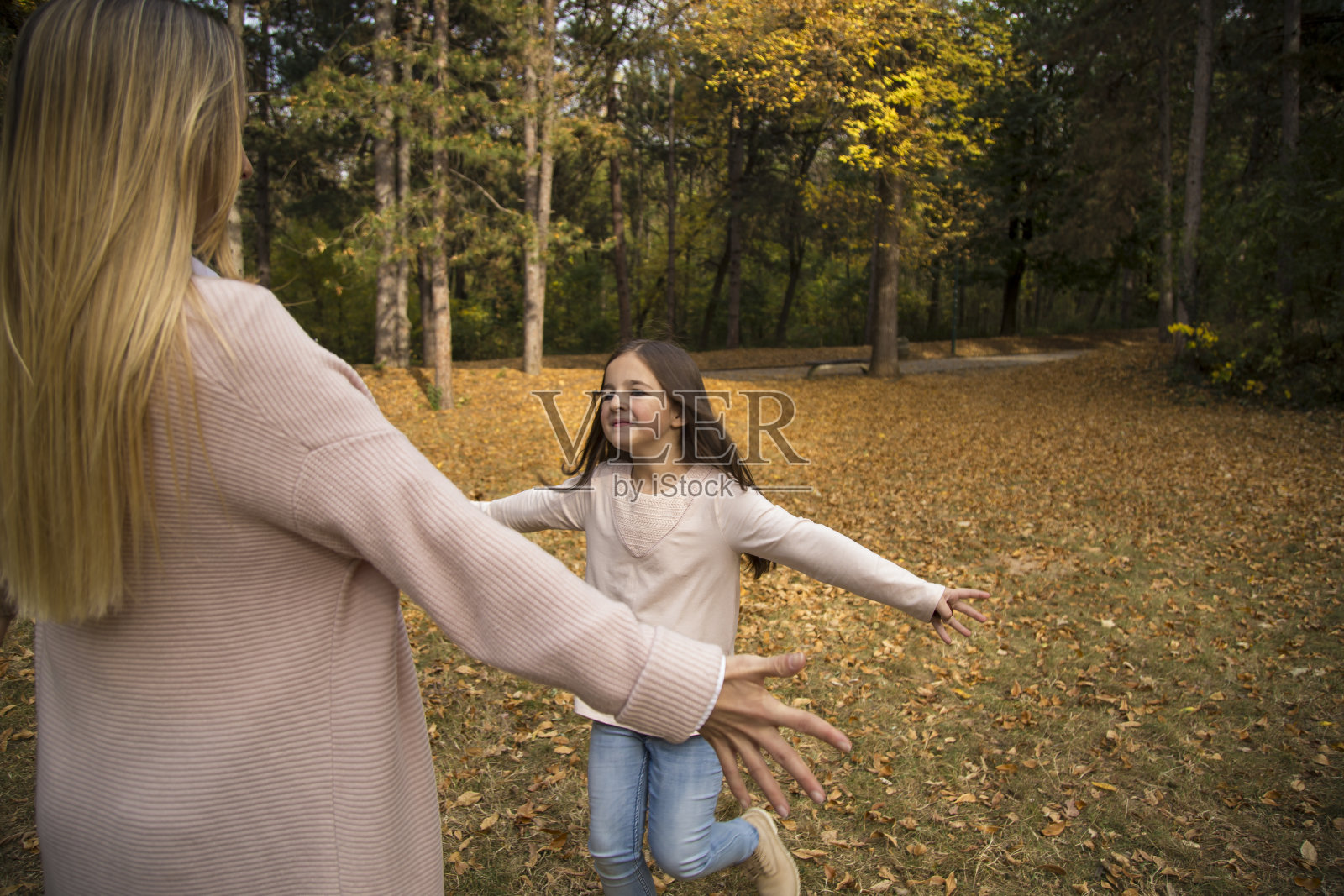 在公园里玩耍的幸福年轻家庭（秋季）照片摄影图片