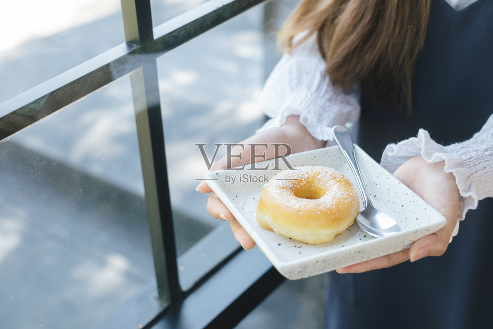 女人拿着一盘甜甜圈，感觉快乐和良好的生活方式在现代咖啡馆照片摄影图片