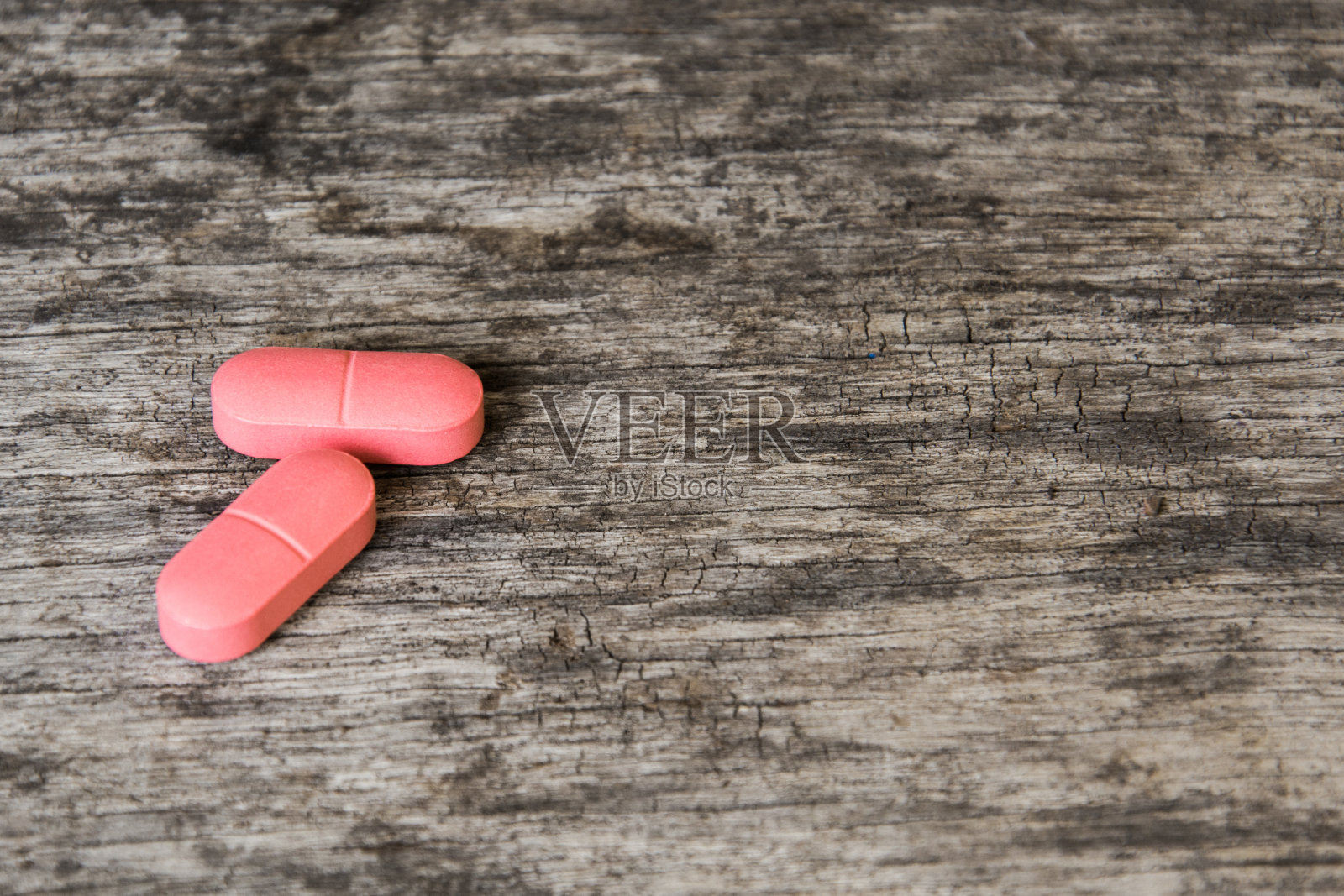 木桌上放着治牙痛的红色药片照片摄影图片