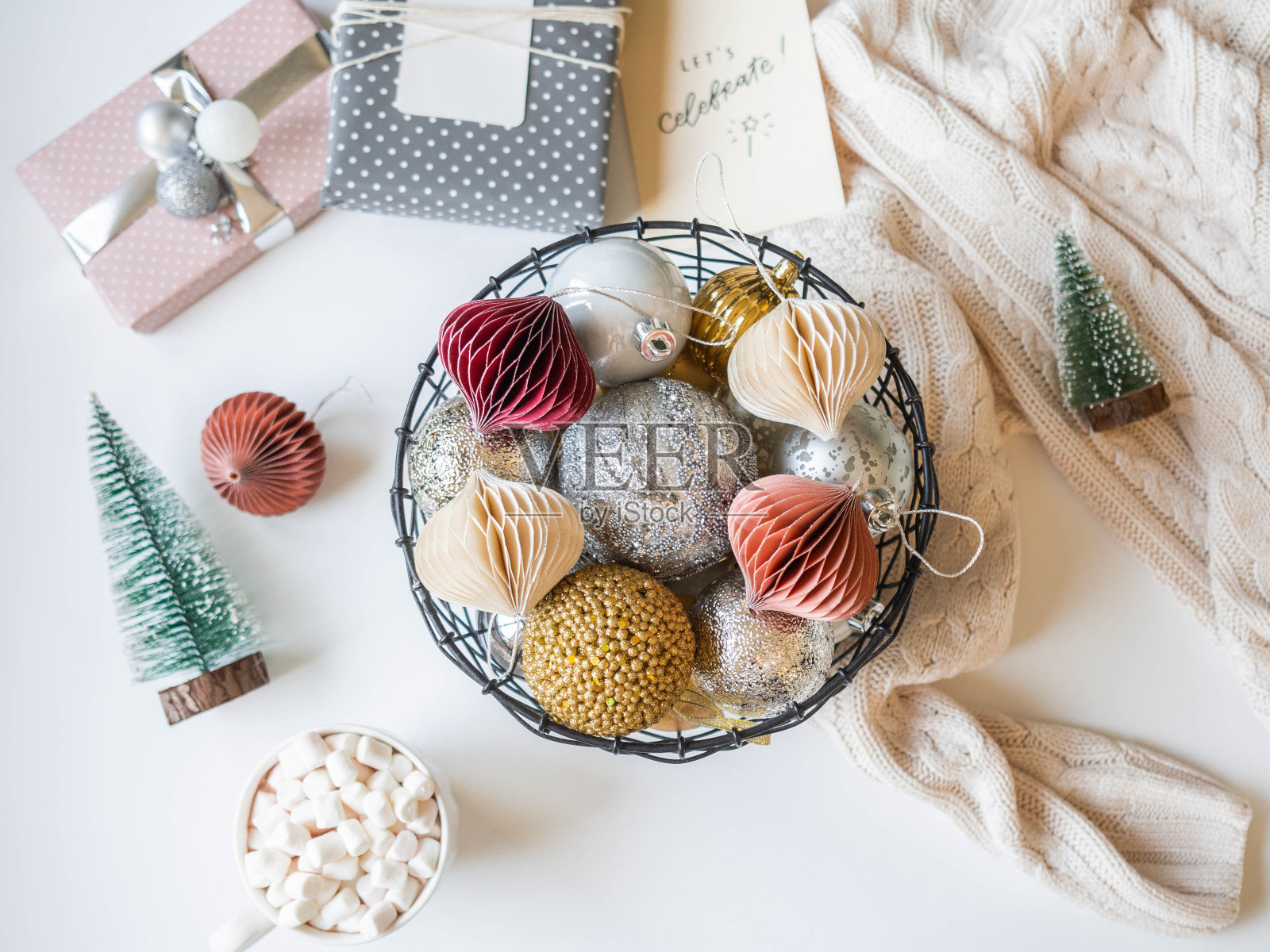 金属柳条篮子与各种金和银圣诞球，热饮杯和圣诞装饰在白色的背景。照片摄影图片