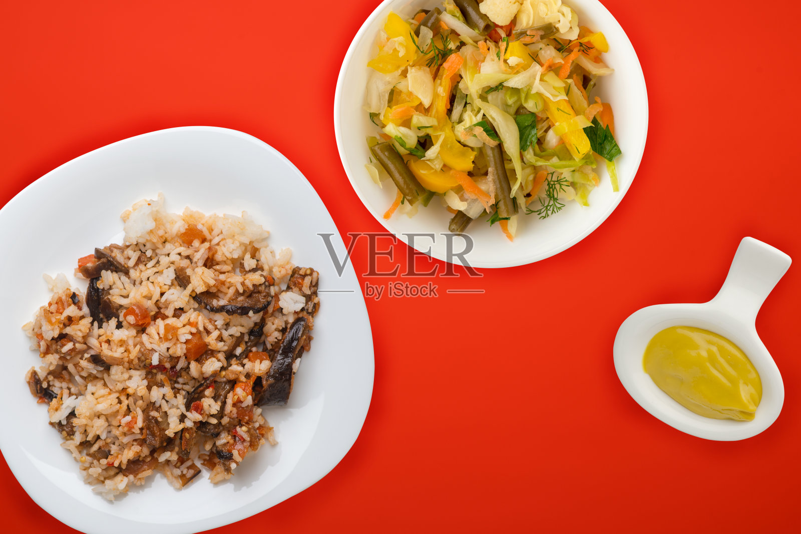 白色盘子里的米饭，配上彩色背景的蔬菜沙拉。白米俯视图。亚洲菜，素食照片摄影图片