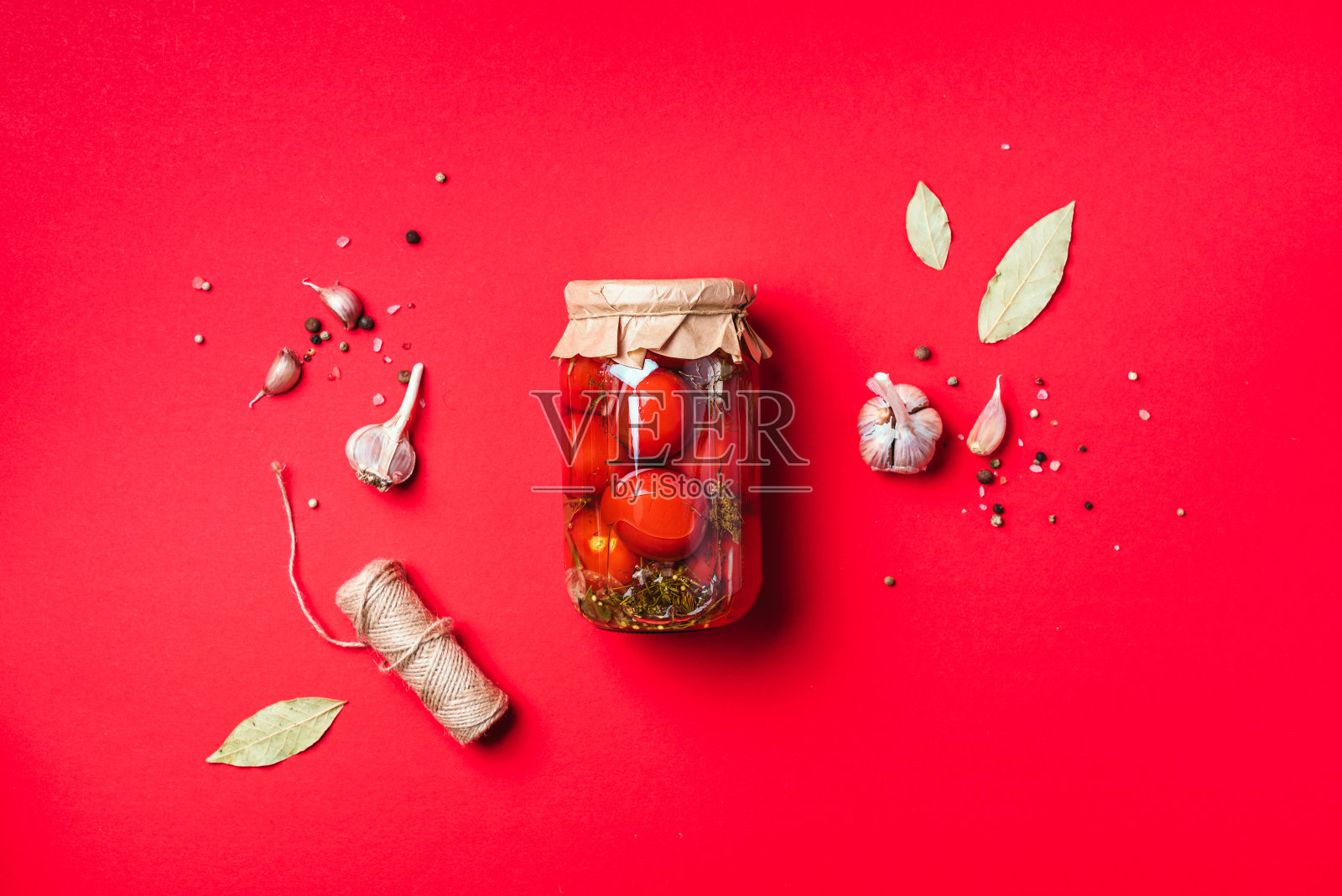 蓝色背景上的罐装腌番茄。前视图。平的。副本的空间。罐头和腌菜。蔬菜保鲜的配料。健康的发酵食品概念。照片摄影图片