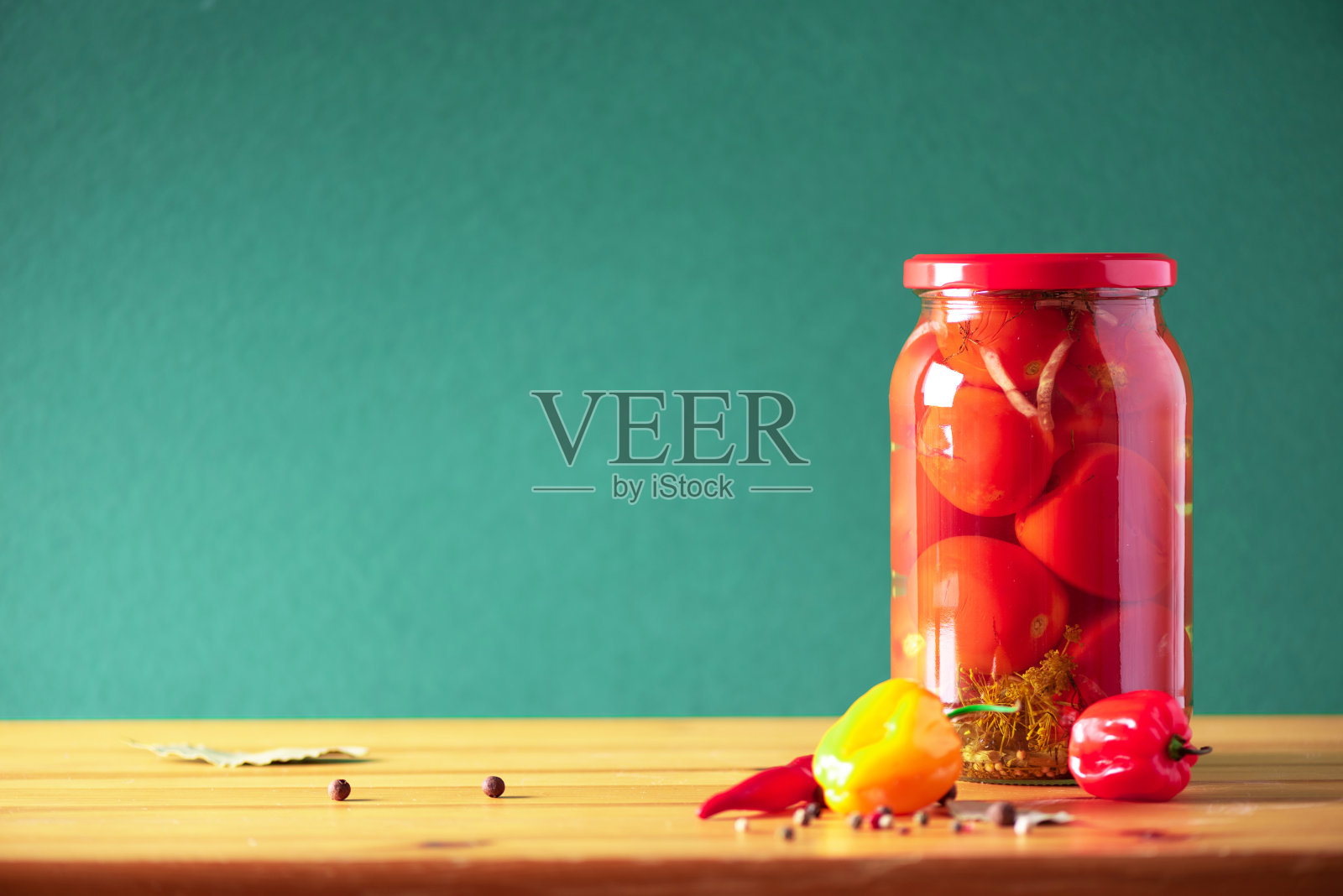 绿色背景的玻璃罐里的腌菜。副本的空间。健康的发酵食品概念。收获的概念照片摄影图片