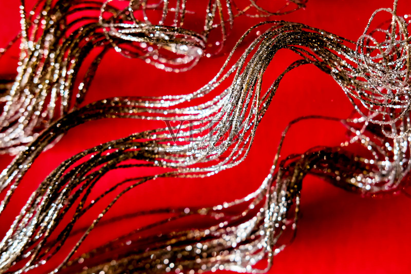 新年和圣诞节的暗色银光装饰在红色的背景上。照片摄影图片