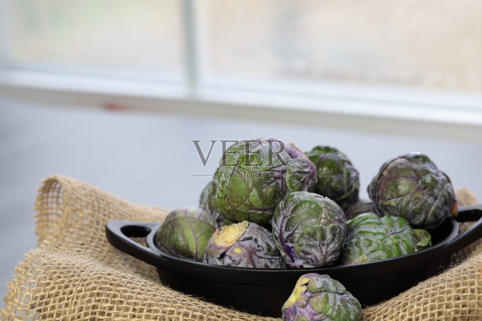 灰色背景上的一碗球芽甘蓝。照片摄影图片