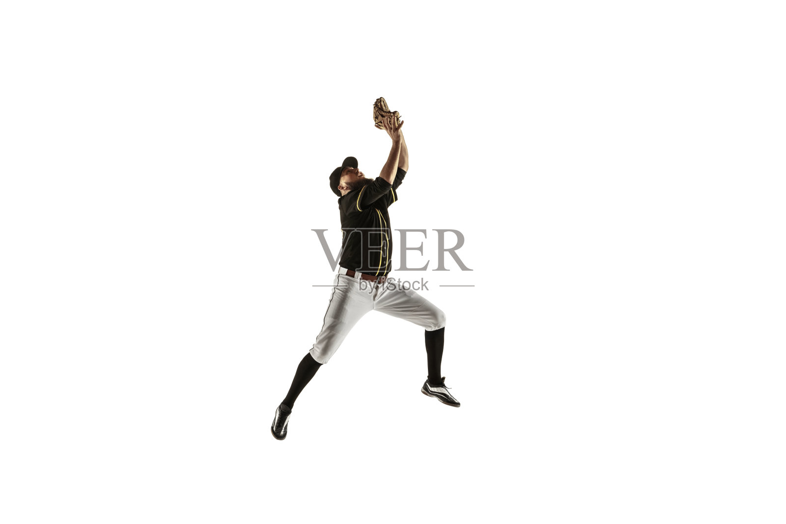 棒球运动员，投手穿着黑色制服在白色背景下练习。照片摄影图片