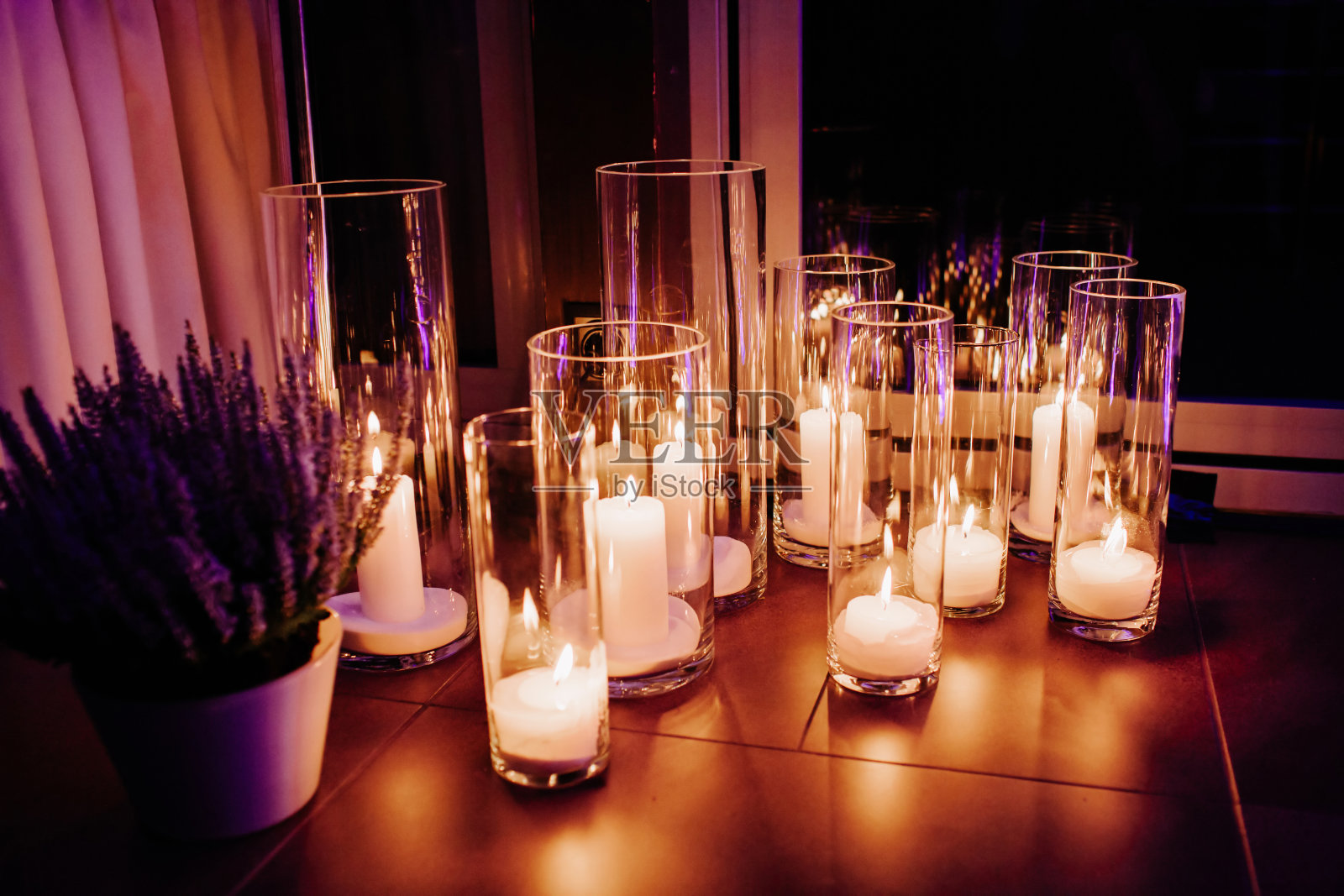 玻璃上装饰着白色燃烧的蜡烛。晚上装饰。照片摄影图片