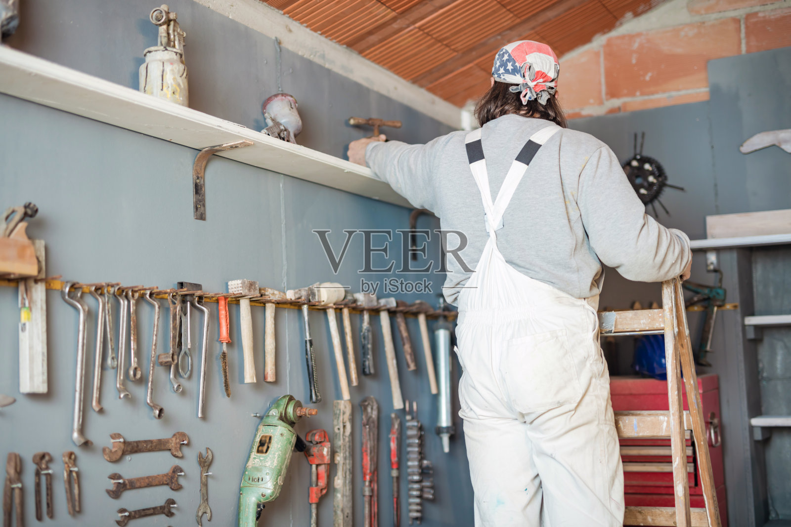 装修、修理和改造室内的杂工，使用工具的工人。照片摄影图片