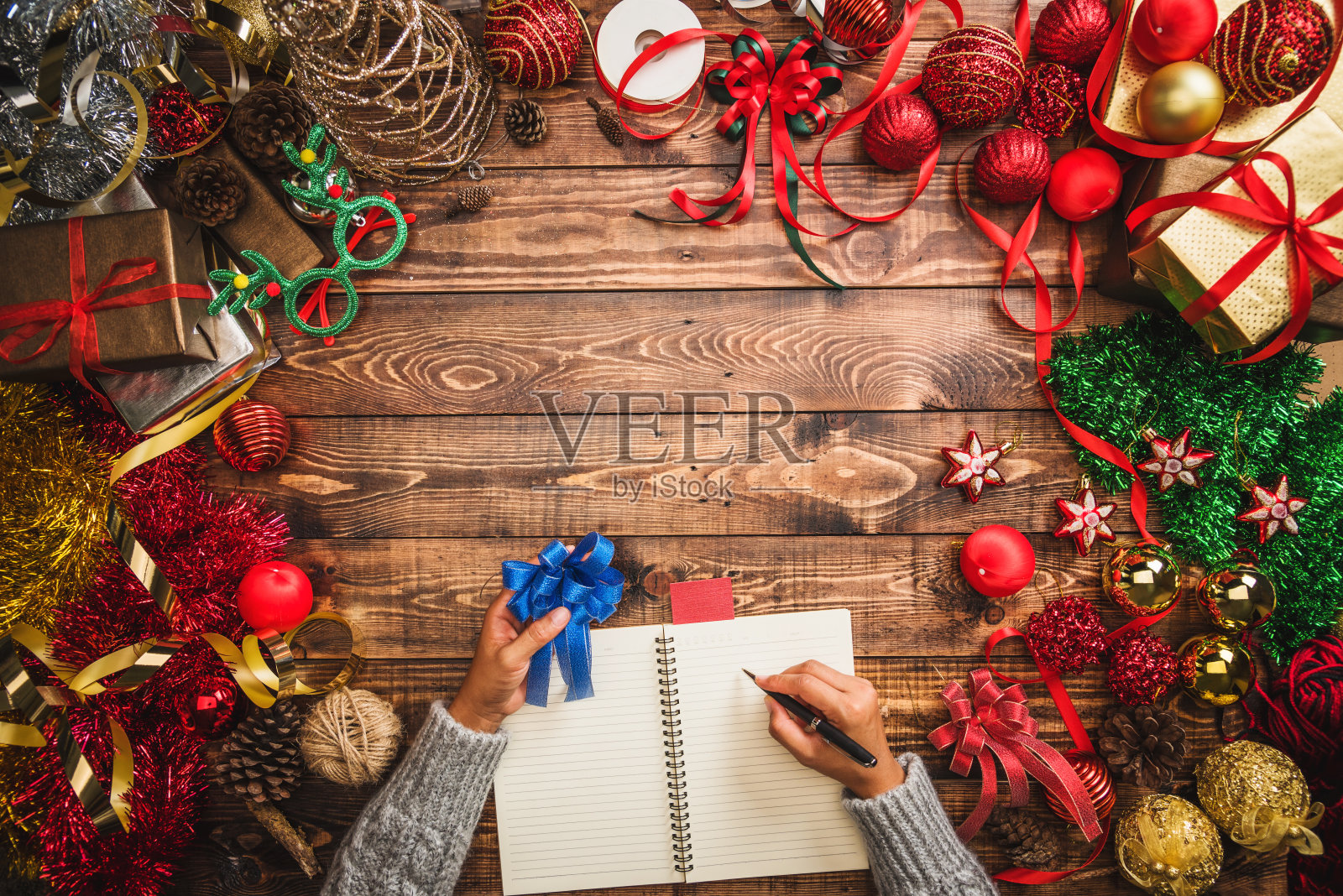 圣诞快乐，恭贺新禧。圣诞组成。礼物，冷杉树枝，球红色的装饰在一个木制的背景与复制空间为您的文本。圣诞节，冬季新年概念。照片摄影图片