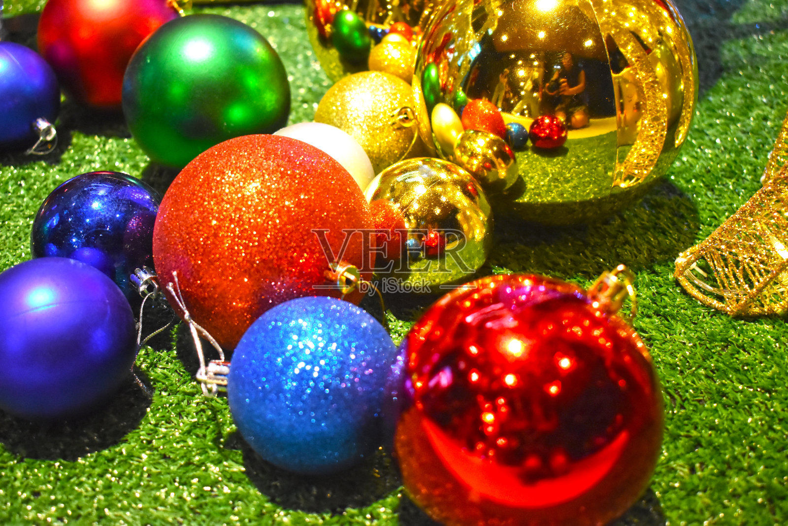 圣诞装饰品绿色地板上五颜六色的球照片摄影图片