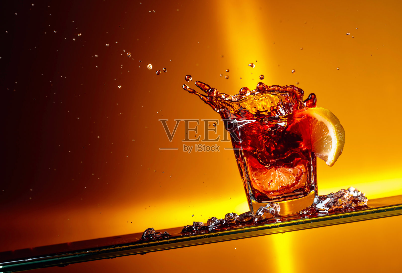 一片柠檬掉进一杯可乐里。照片摄影图片