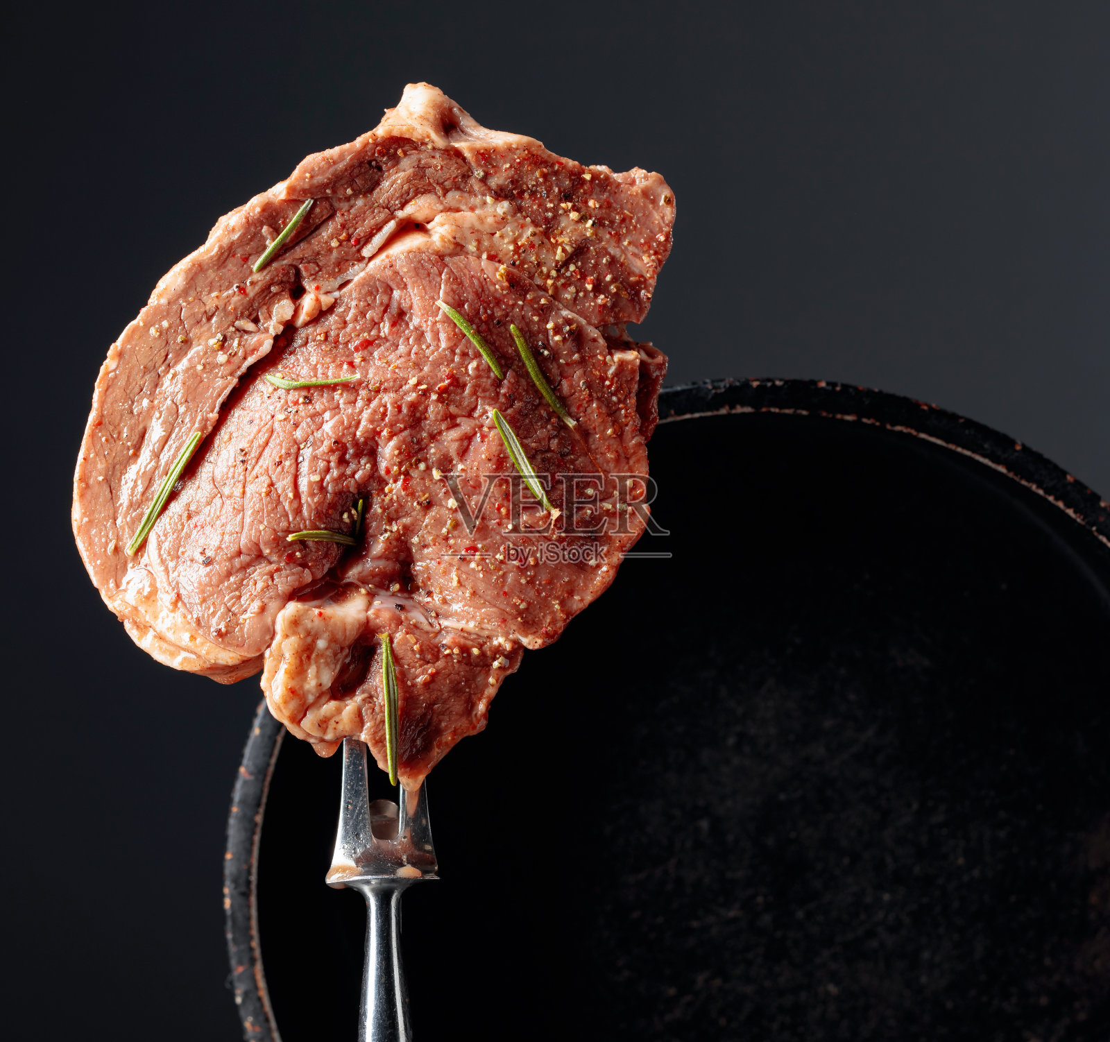 搭配香料和迷迭香的预制牛排照片摄影图片