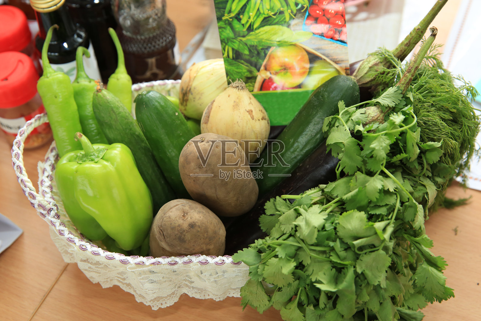 新鲜蔬菜。篮子里有辣椒、黄瓜、洋葱、土豆、青菜、泡菜和茄子。照片摄影图片