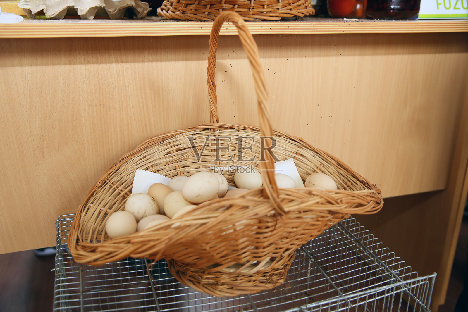 柳条篮子里的鸡蛋。复活节彩蛋。篮子里的白鸡蛋。关闭了。蛋黄是黄色和白色的。木桌上放着一篮子白鸡蛋。照片摄影图片