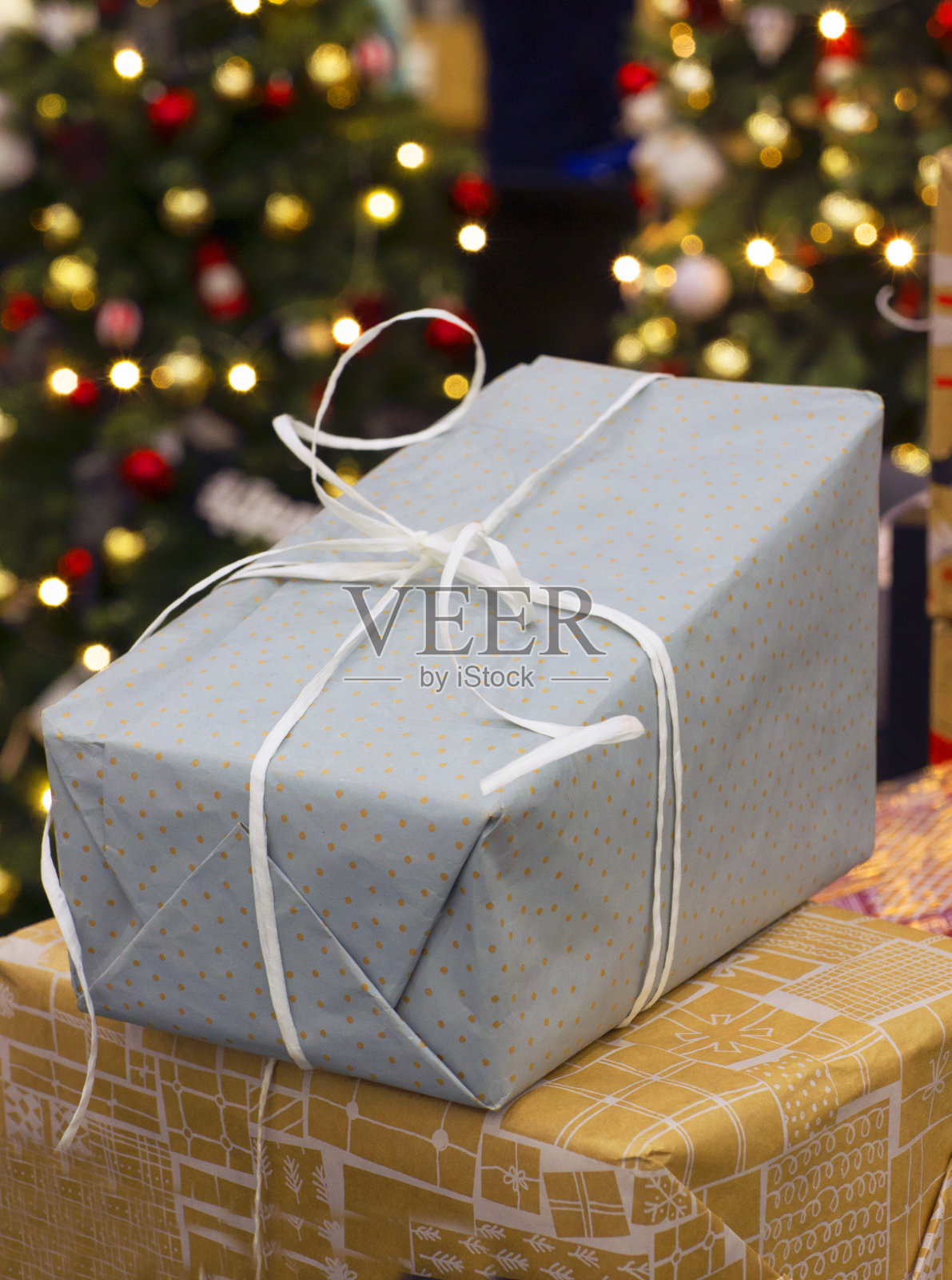 圣诞树与玩具和灯，节日礼物在一个盒子在前景照片摄影图片