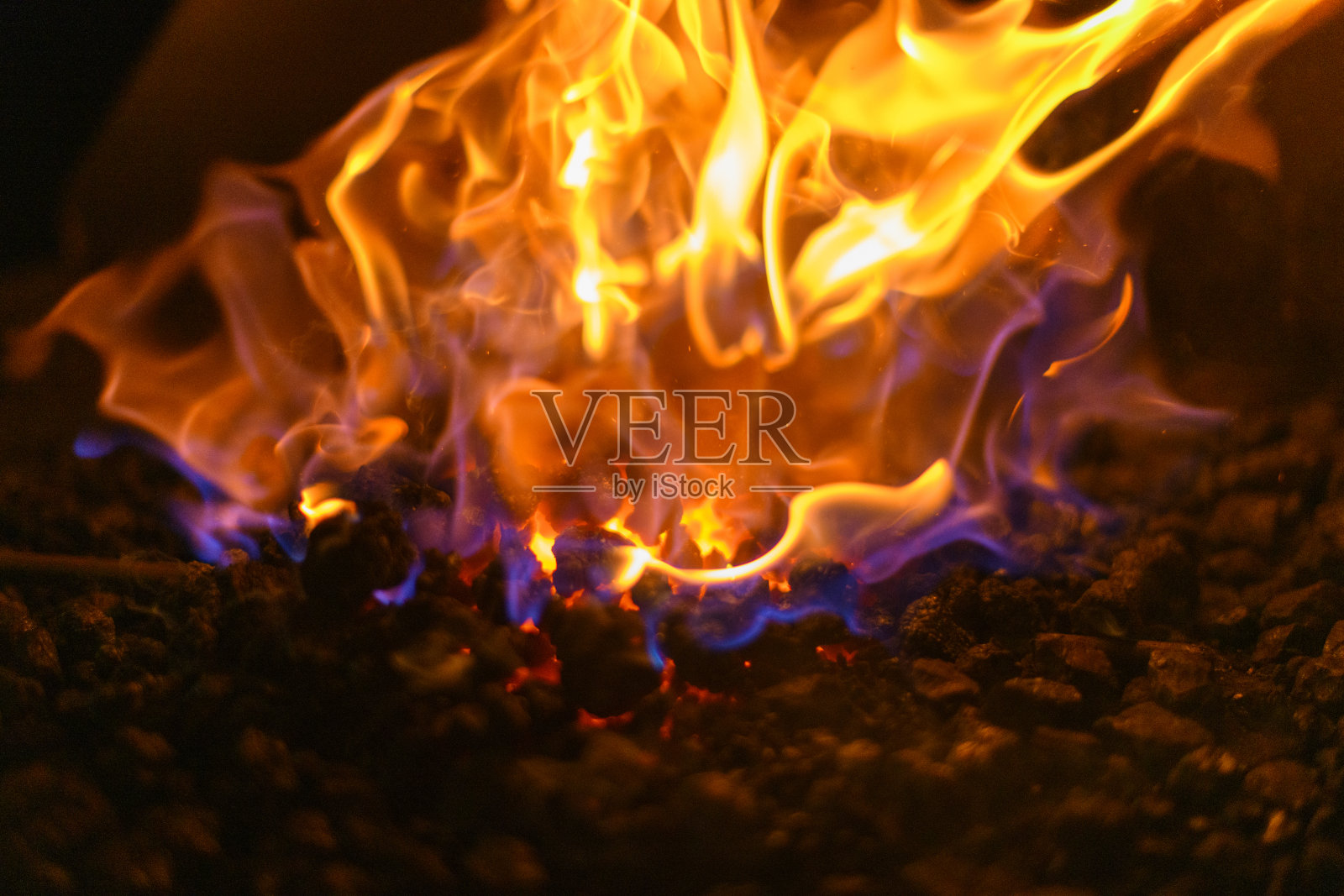 彩色的火焰从一个炽热的煤火在壁炉靠近照片摄影图片