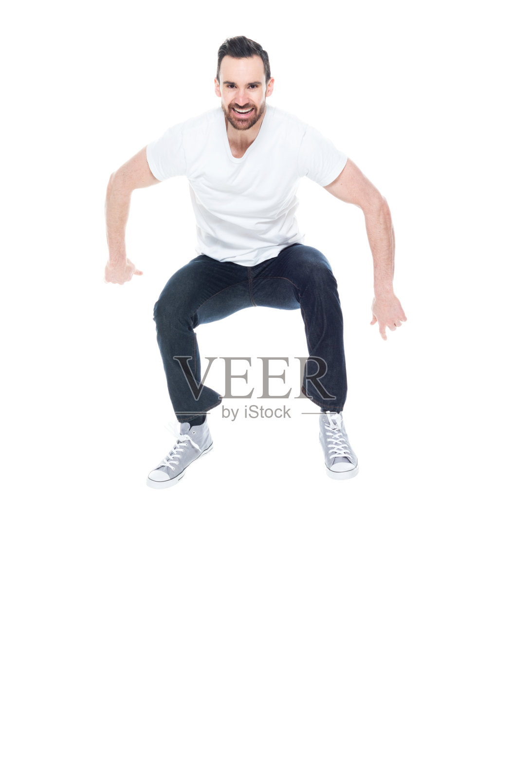 一人独长/ 30-39岁的成年帅哥/白种人男性/年轻男子跳着穿着牛仔裤谁是喜悦/兴奋/微笑/快乐/开朗/酷的态度照片摄影图片