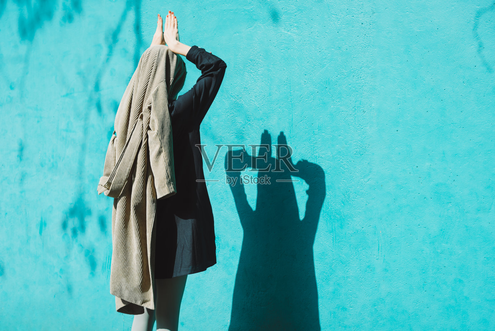 站在墙前的女人。照片摄影图片