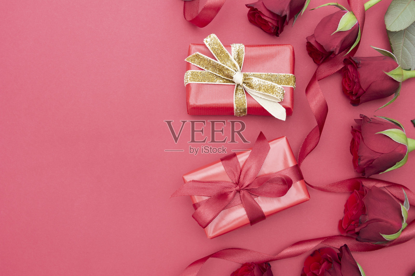 情人节：红色背景上的红玫瑰、礼品盒和丝带照片摄影图片