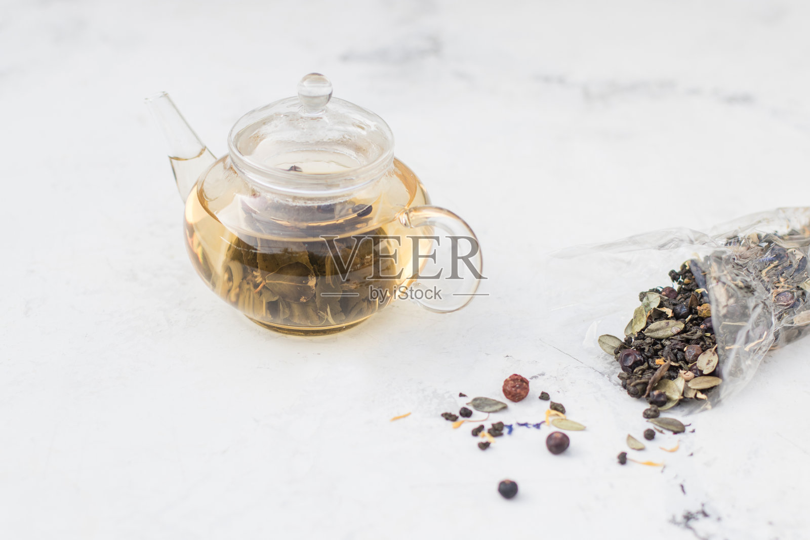 杯子茶壶里的茶。草药茶与浆果和蜂蜜照片摄影图片