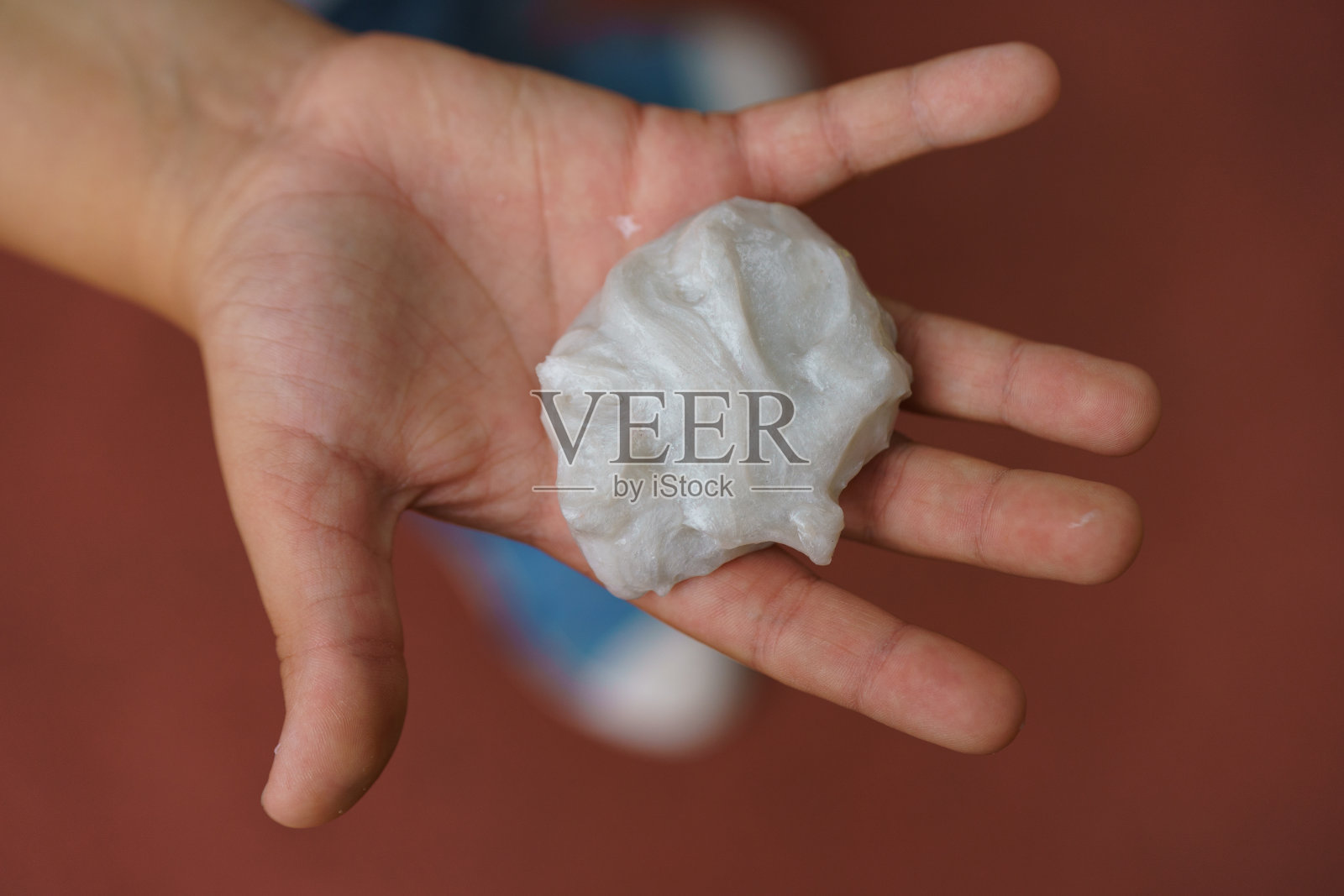 孩子手里拿着白色的自制黏液照片摄影图片