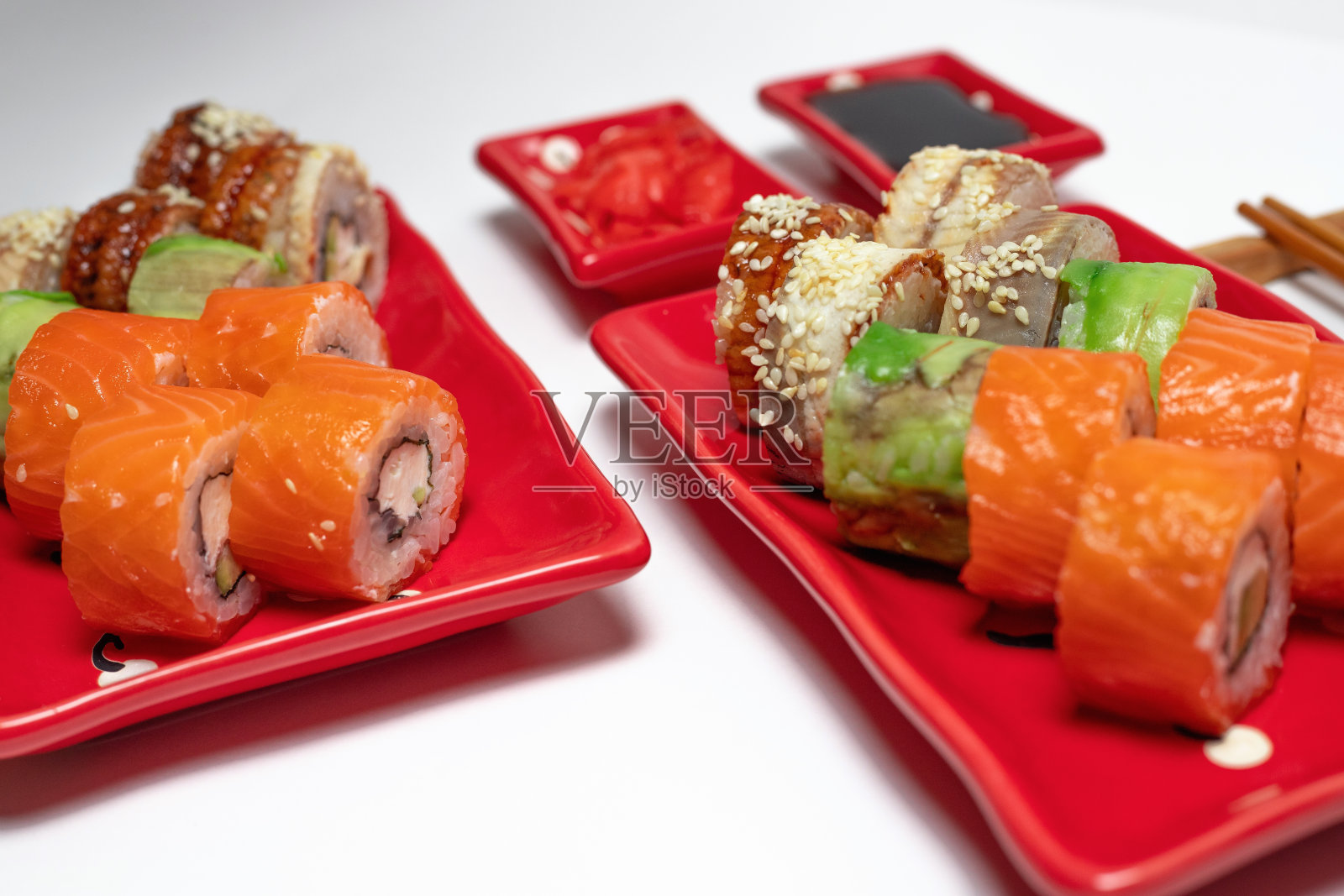 美味的寿司和卷在一个红色的盘子在白色的背景。照片摄影图片