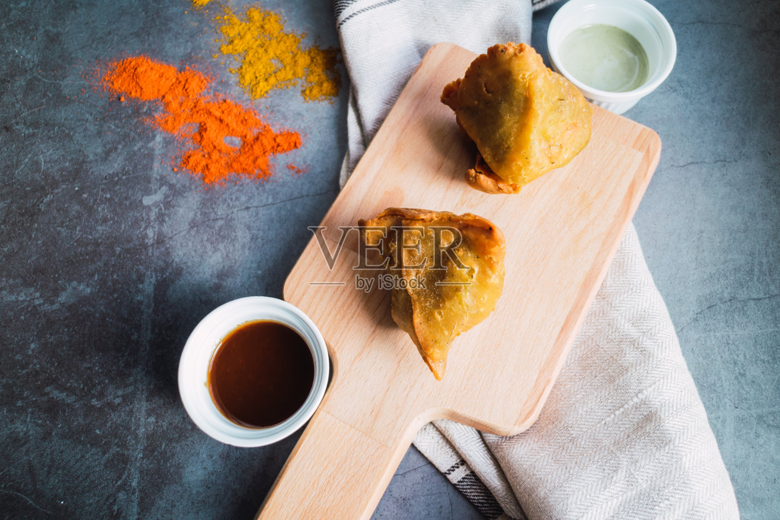 印度旁遮普三角面包，土豆，豌豆和洋葱，混凝土背景。素食产品。前视图。照片摄影图片