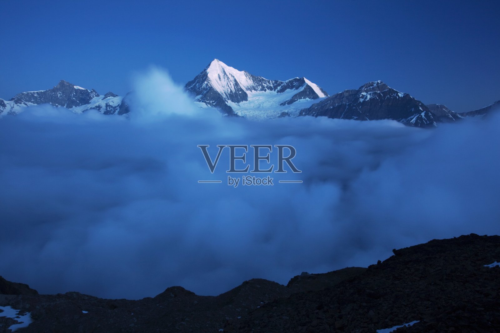 瑞士阿尔卑斯山泽马特附近的魏斯峰和马特洪山被雪覆盖的景观。云中瑞士魏斯霍恩和周围山脉的全景。夏季登山季节照片摄影图片