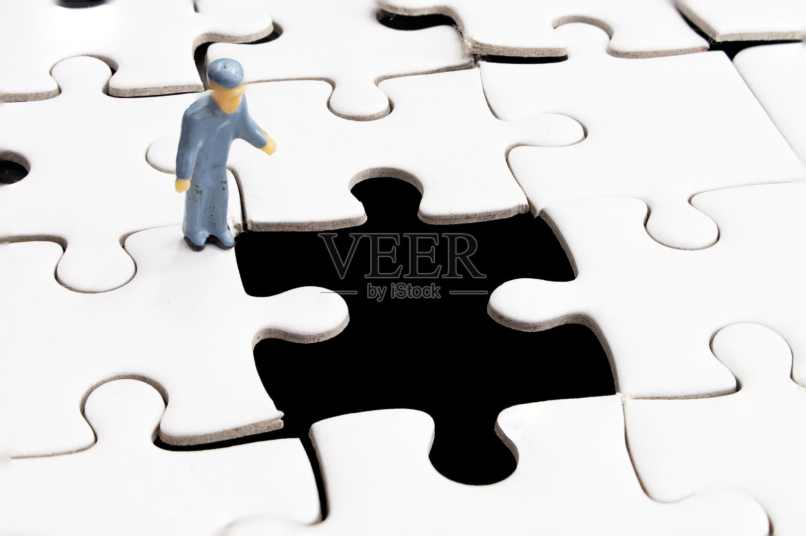 拼图白色块和微型人或小图形工人。照片摄影图片