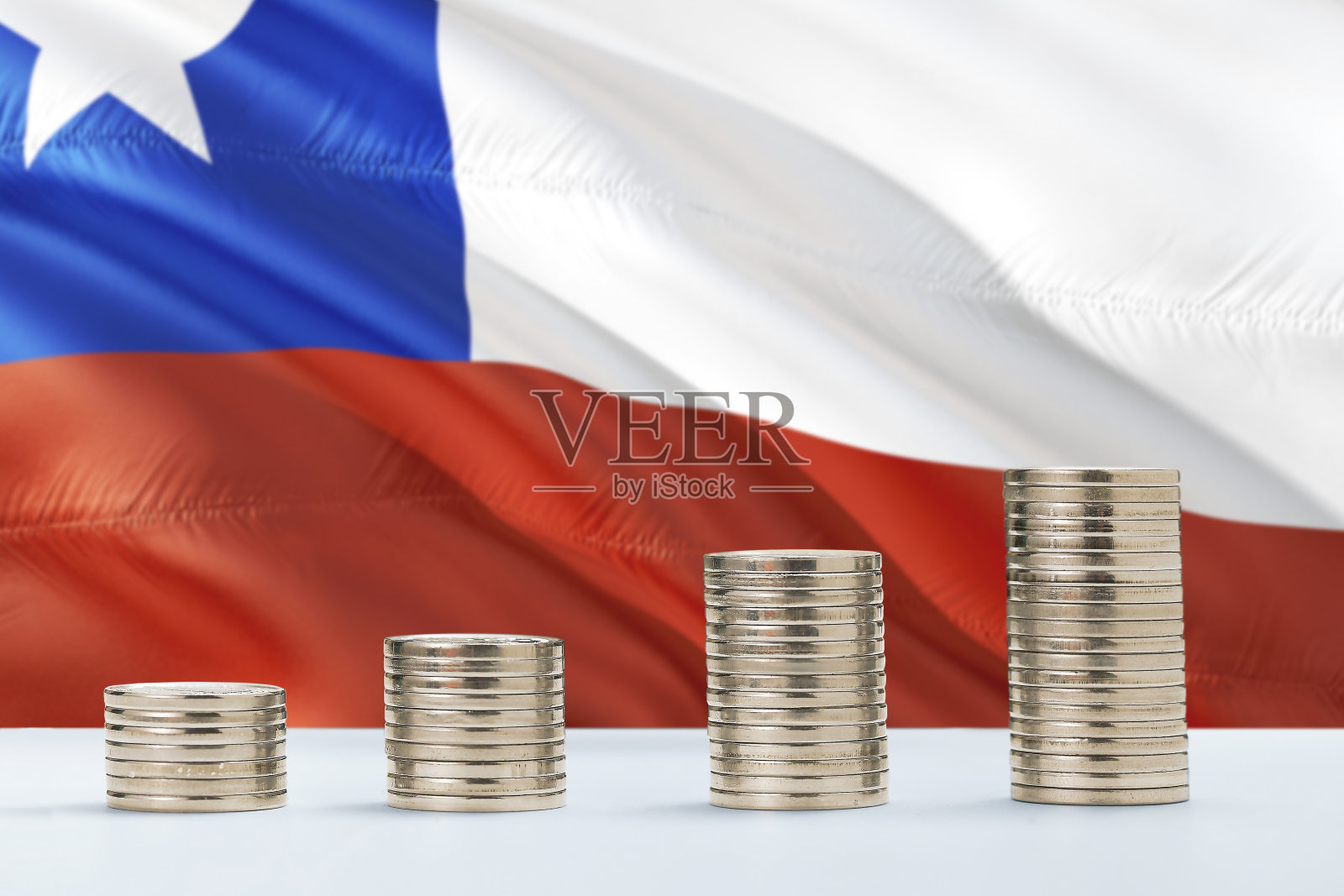 智利国旗在硬币背景中飘扬，金融商务概念，储蓄照片摄影图片