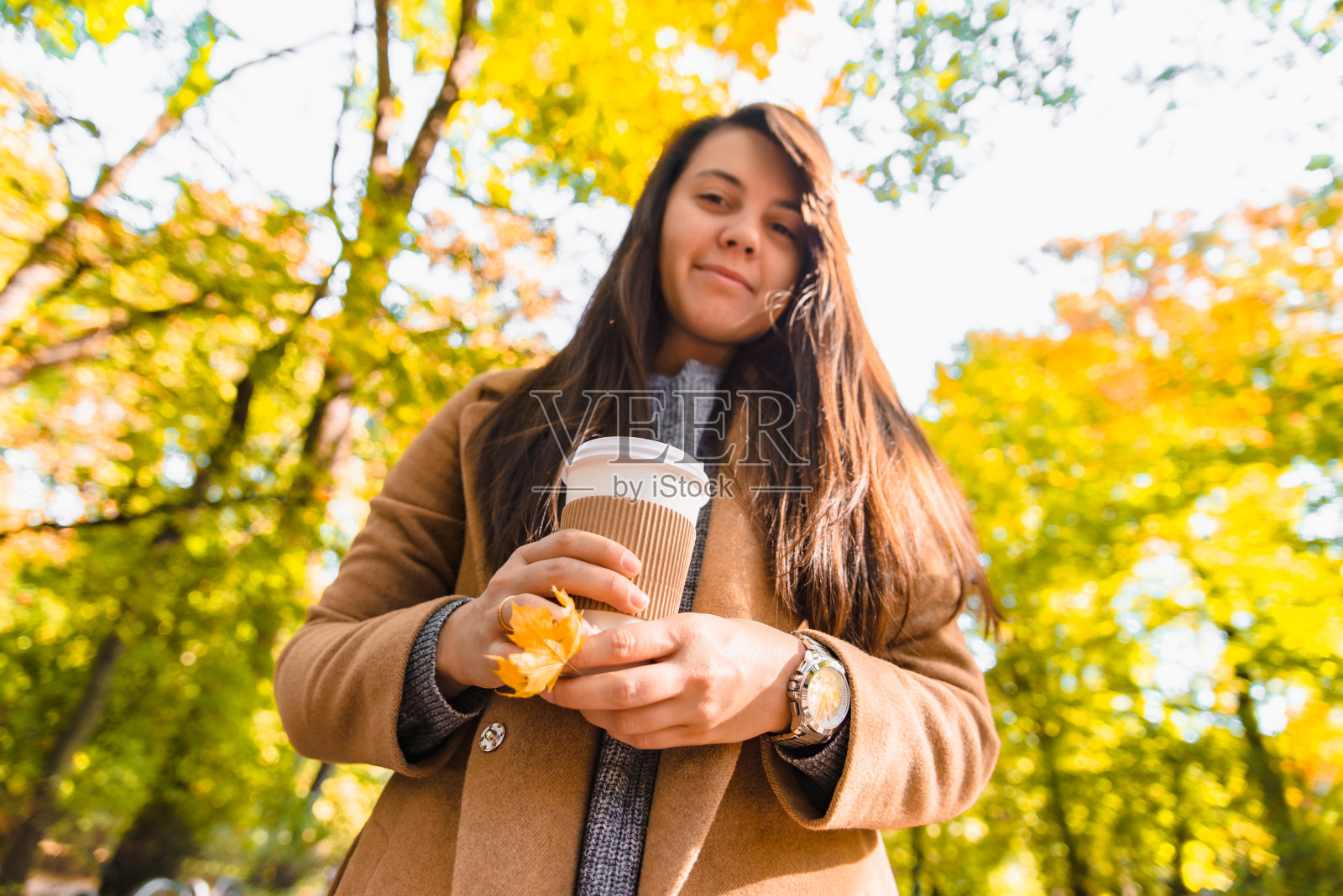 女人拿着外带咖啡杯，秋季照片摄影图片