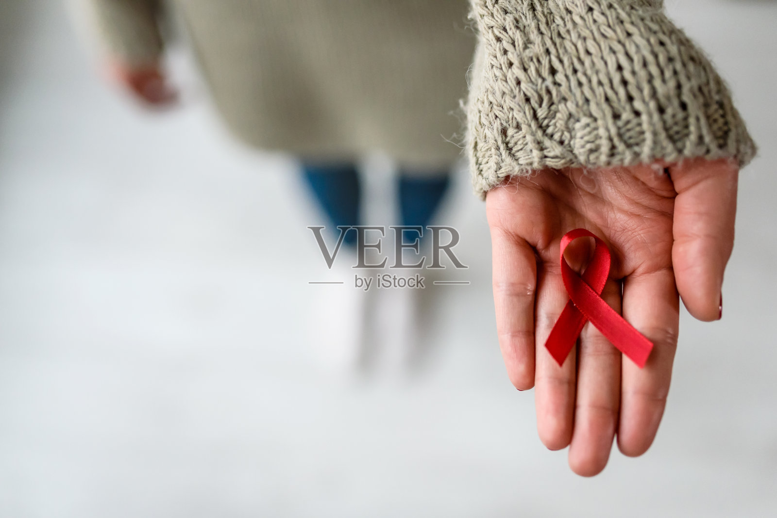 手里拿着红丝带的女人。艾滋病意识的象征照片摄影图片