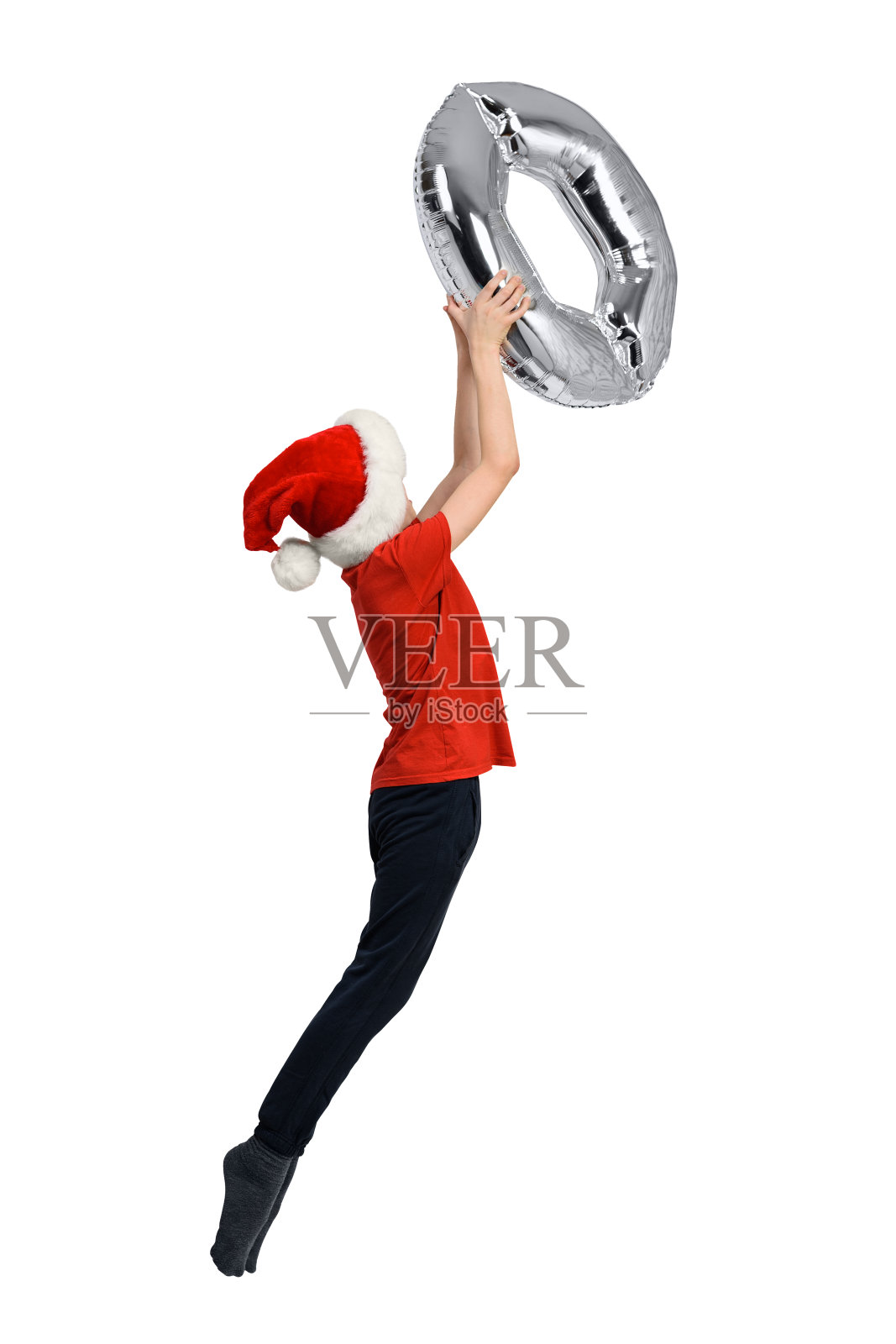 戴红帽的跳跃男孩手中的银色充气零。白色背景照片摄影图片