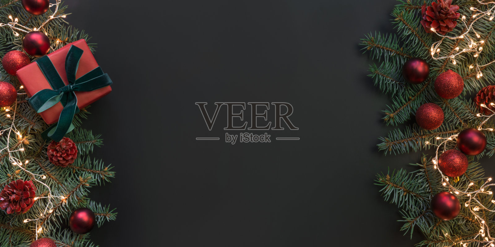 圣诞框架与礼品盒，常青树的树枝，红色的球在黑色。空间的文本。照片摄影图片